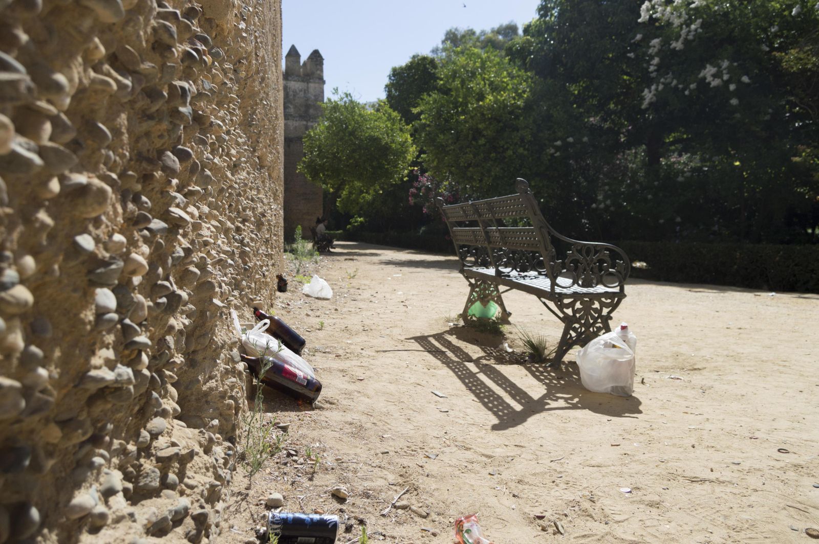 Restos de una 'botellona' junto al tramo de muralla almohade que rodea los jardines. La foto está realizada a las 11:30. / JULIÁN VENEGAS