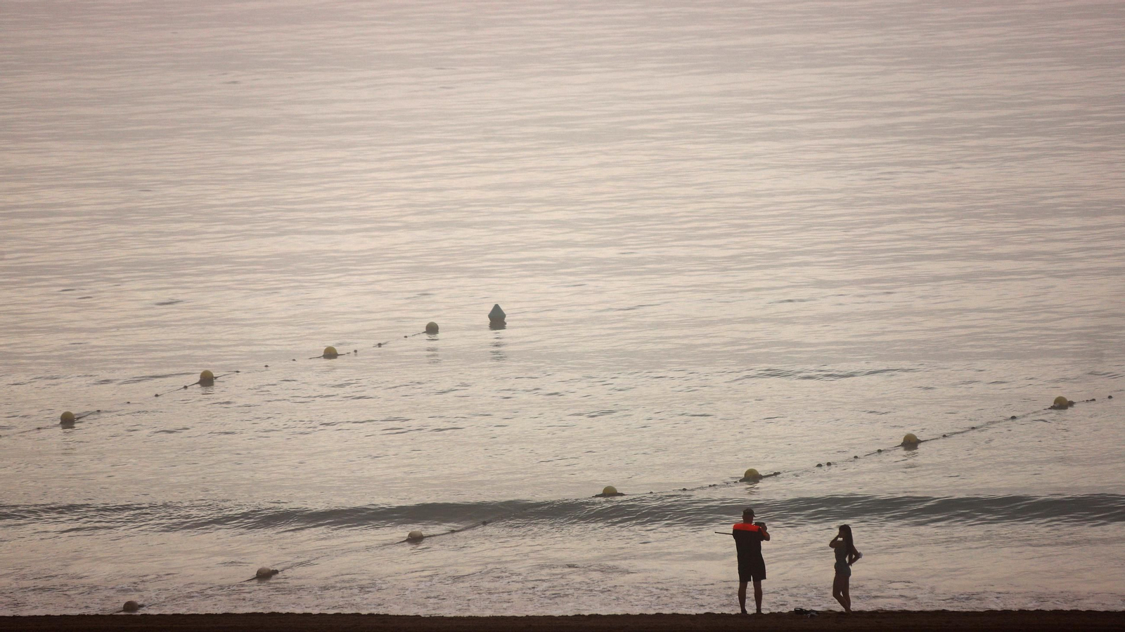 Dos personas en la playa de Getares.