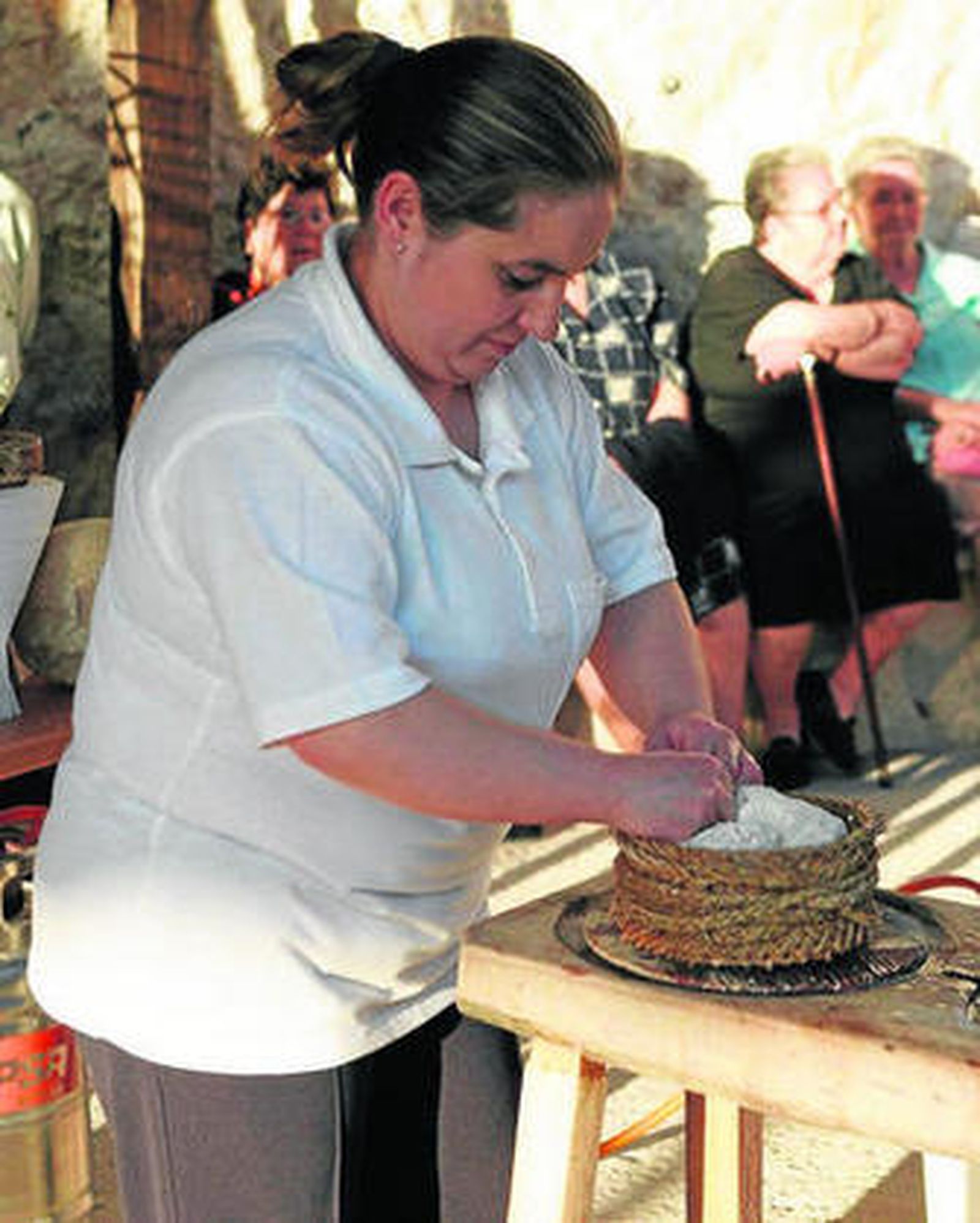 Una mujer en pleno proceso de fabricación de un queso.