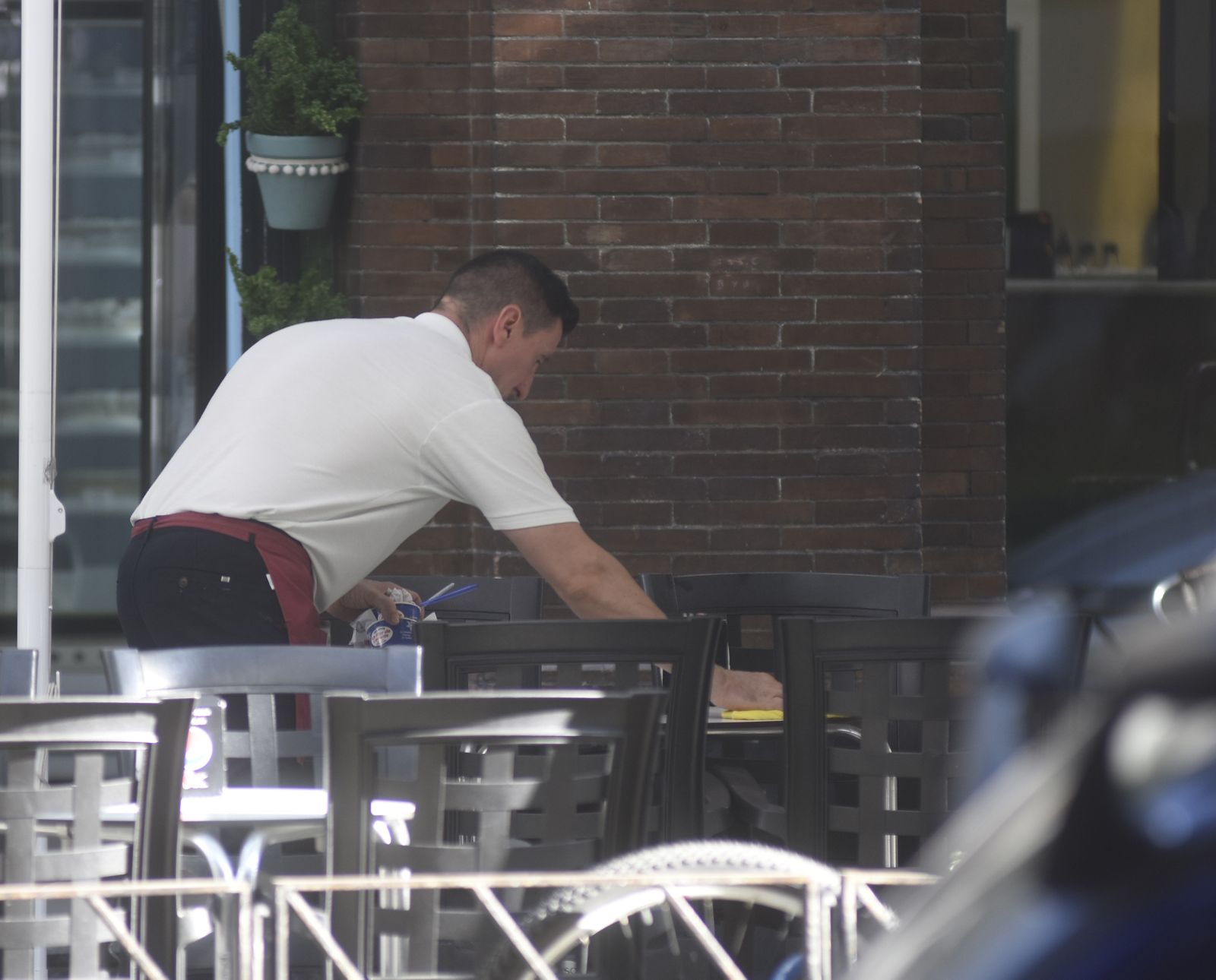 Un camarero limpia la mesa de un establecimiento.