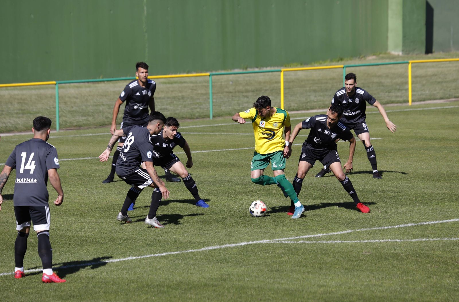 Varios jugadores del Utrera rodean a un jugador de Los Barrios.