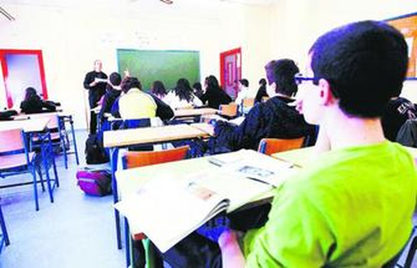 Alumnos atendiendo a un profesor en clase.