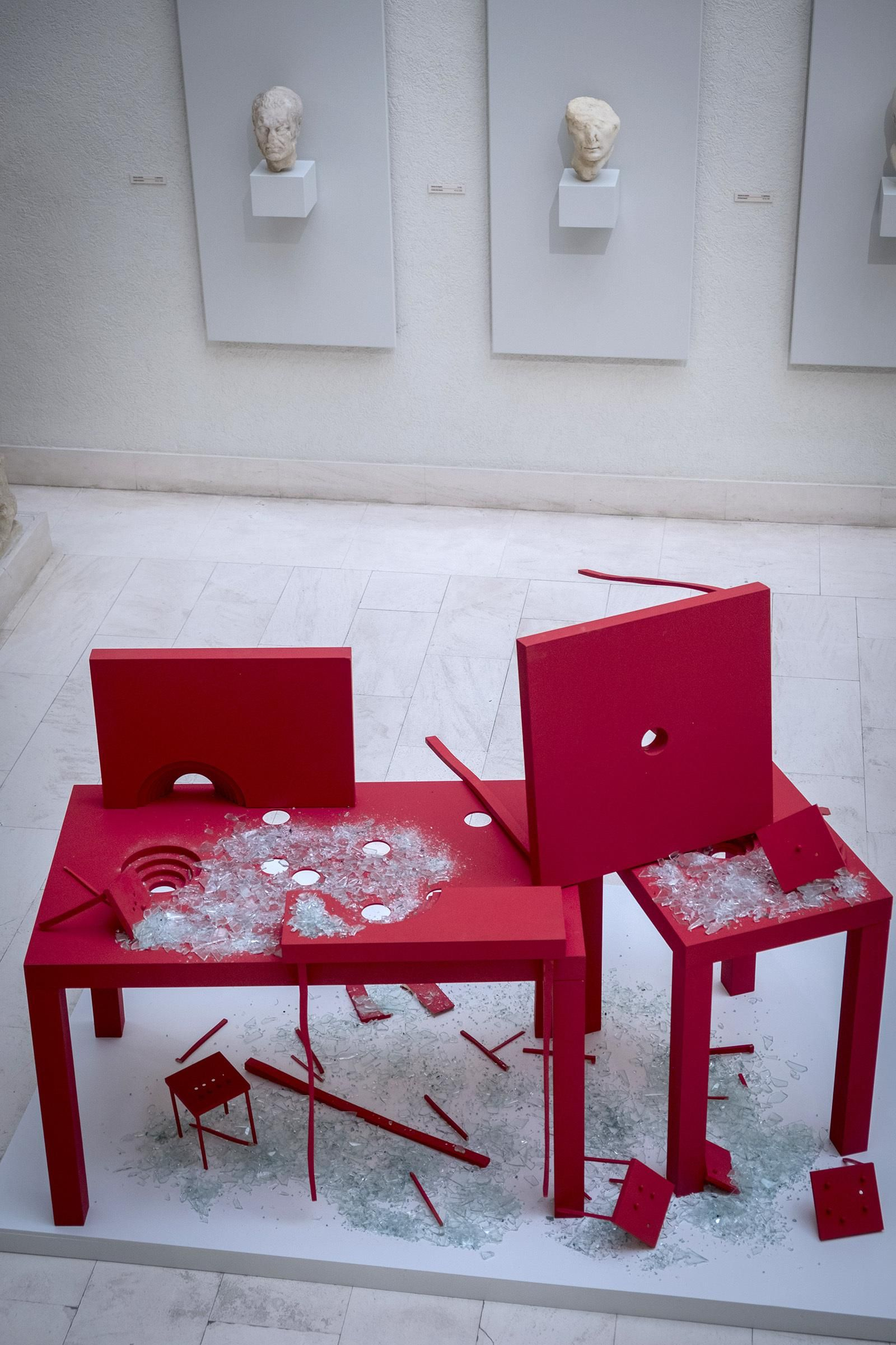 -La sorprendente pieza 'Desastres provocados, desastres controlados', de Francisco Almengló, luce bajo la colosal escultura de Trajano en el patio del Museo. Un bello contraste entre el dinámico rojo que ofrece la pieza, frente al blanco sosegado del espacio.