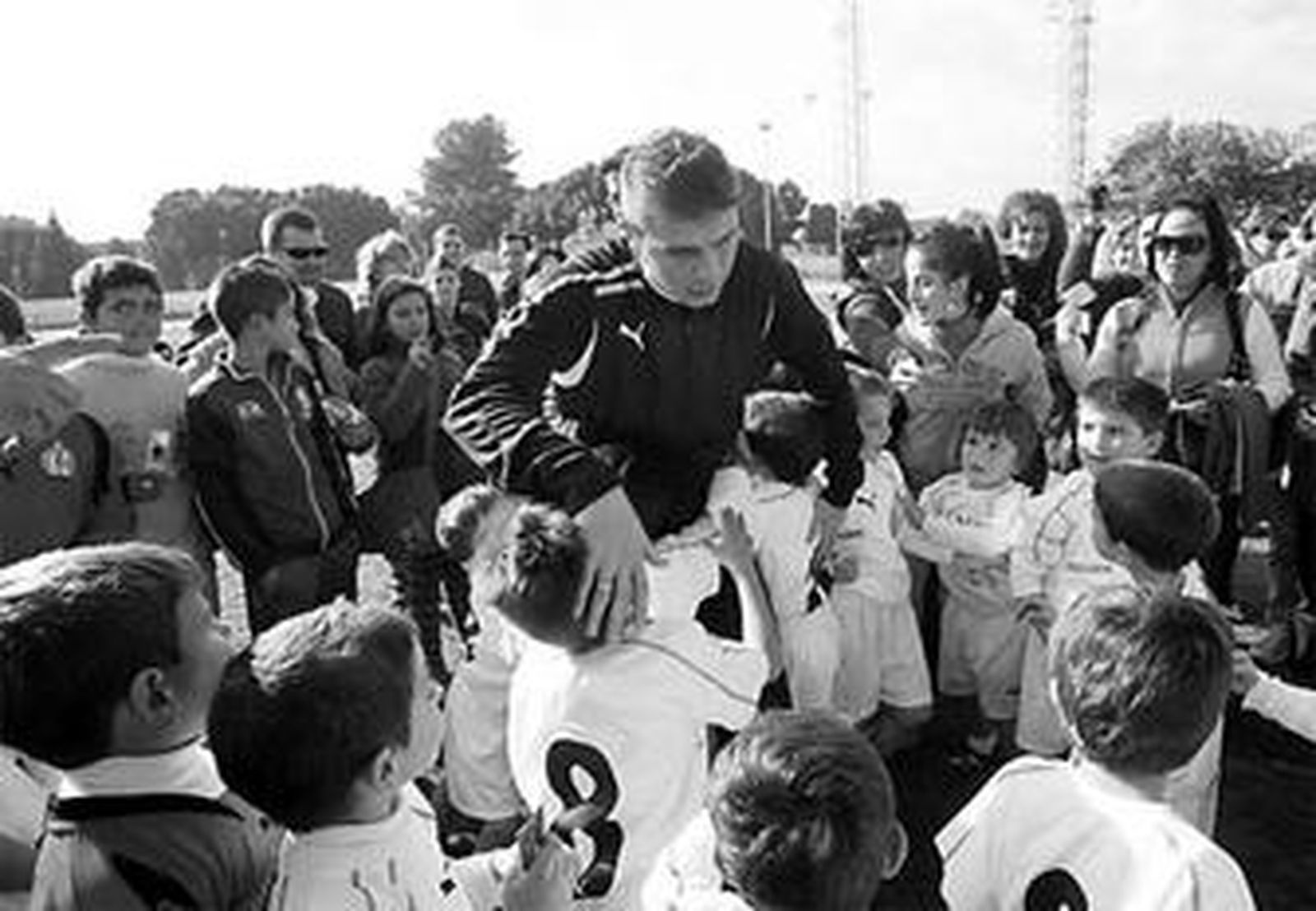 Joaquín se abraza con un grupo de jóvenes jugadores.