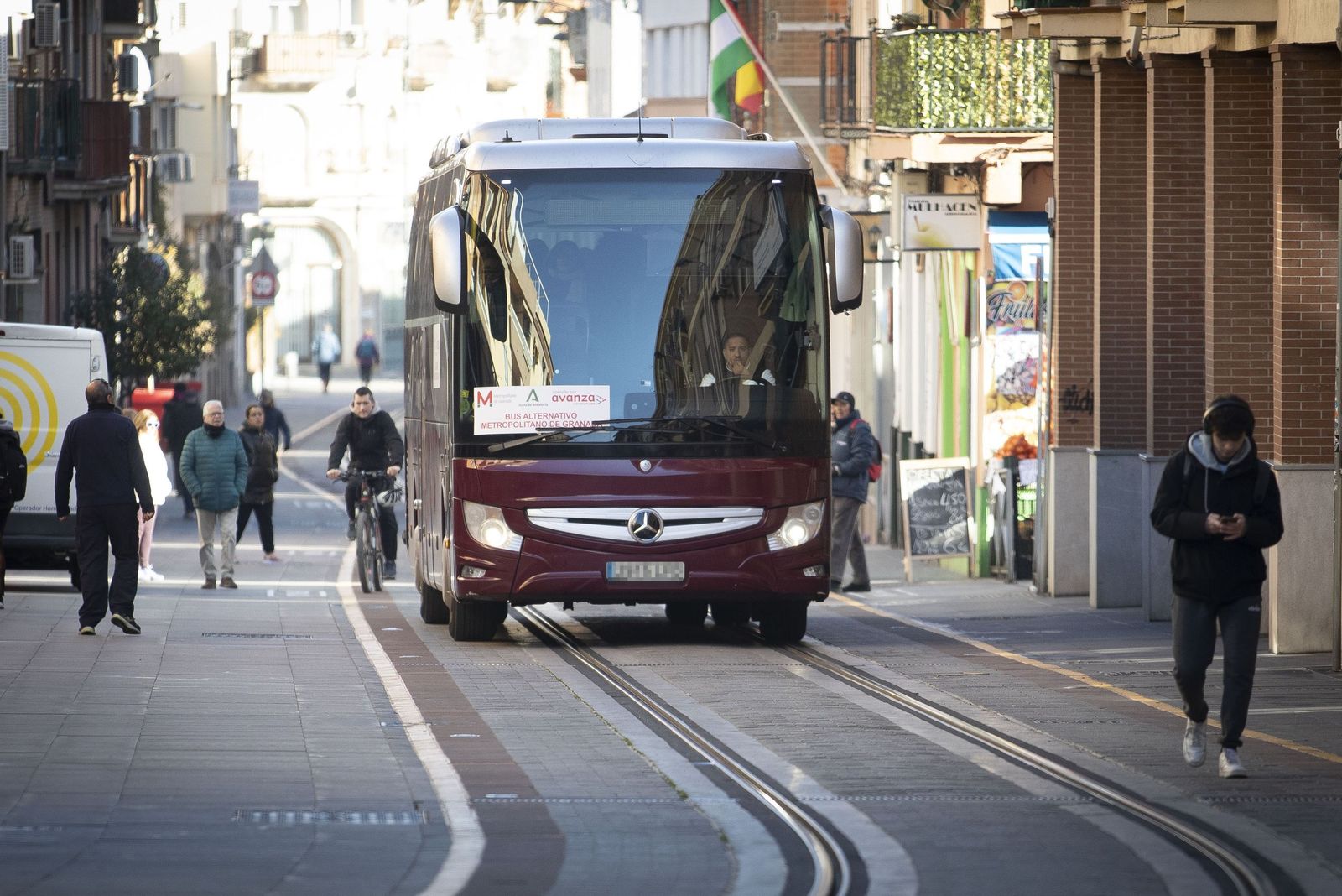 El autobús lanzadera circulando por la calle Real de Armilla, por encima de las vías del Metro