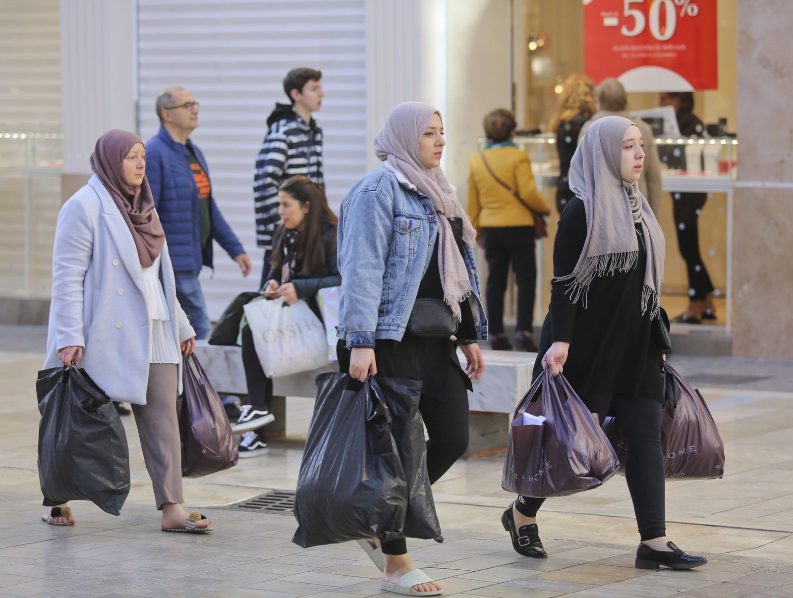 Un grupo de personas, con bolsas por el centro