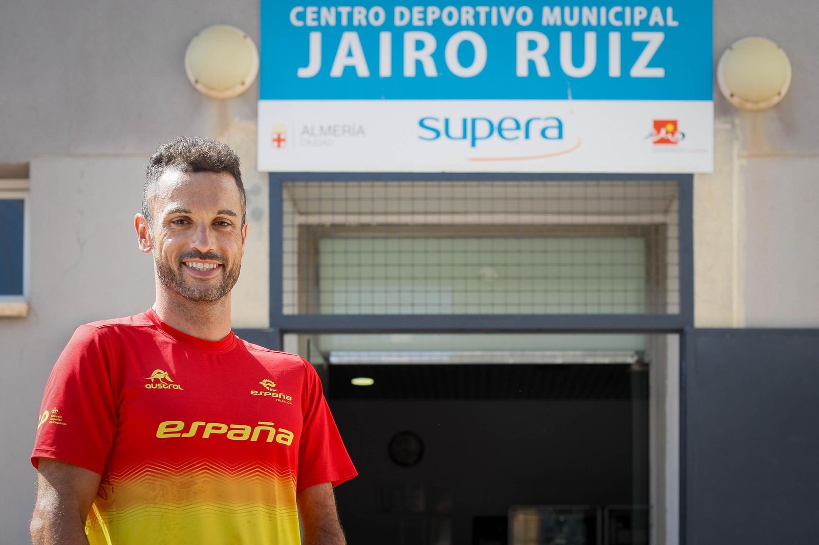 El triatleta paralímpico almeriense posa junto al pabellón que lleva su nombre en la barriada de Los Ángeles.