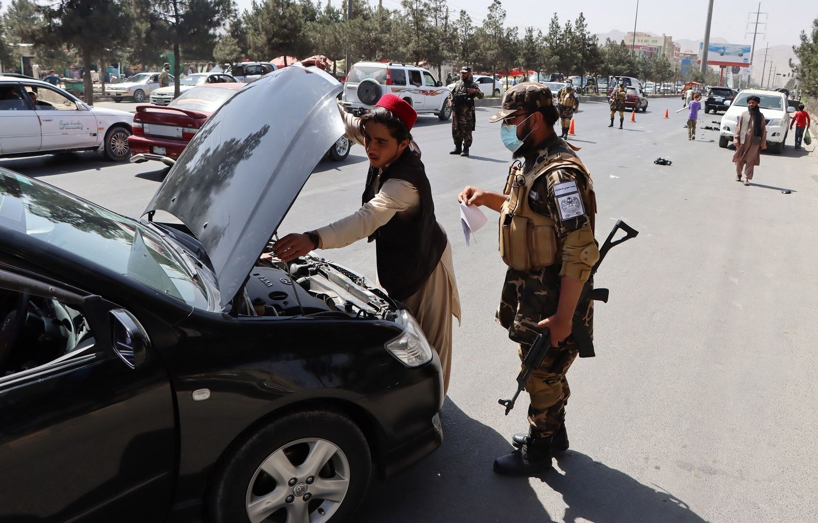 Fuerzas talibanes registran un vehículo en una carretera de Kabul.