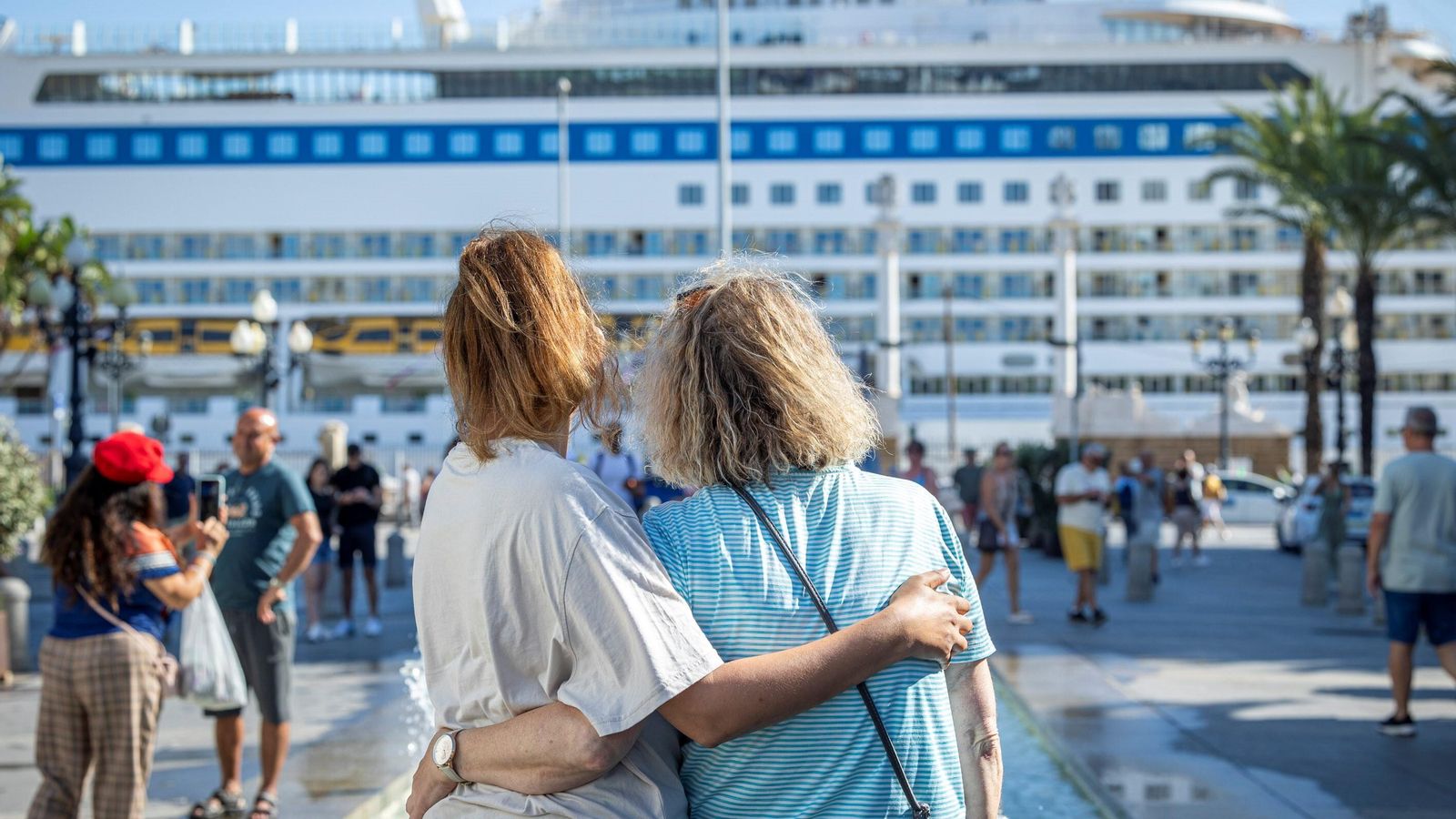 Dos personas dirigen sus miradas hacia uno de los cinco cruceros llegados este miércoles a Cádiz