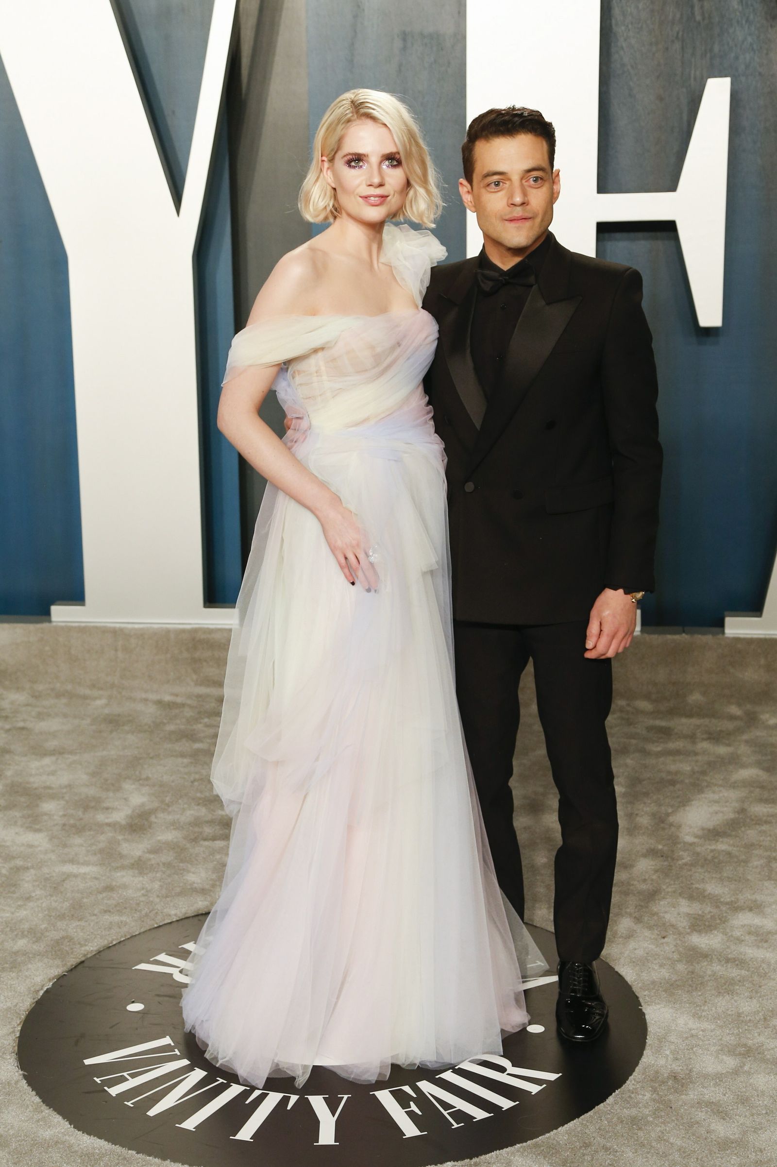 Lucy Boynton, no muy acertada en su vestido, con su pareja, Rami Malek.