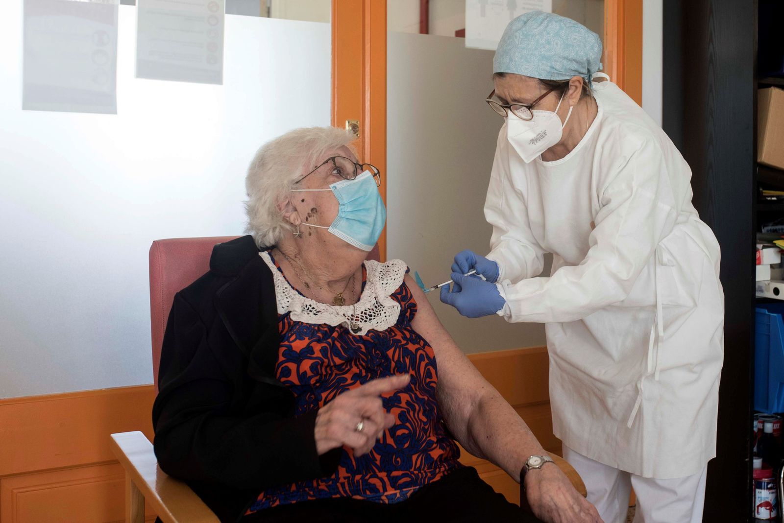 Una sanitaria inocula la vacuna  a una usuaria de una residencia geriátrica.