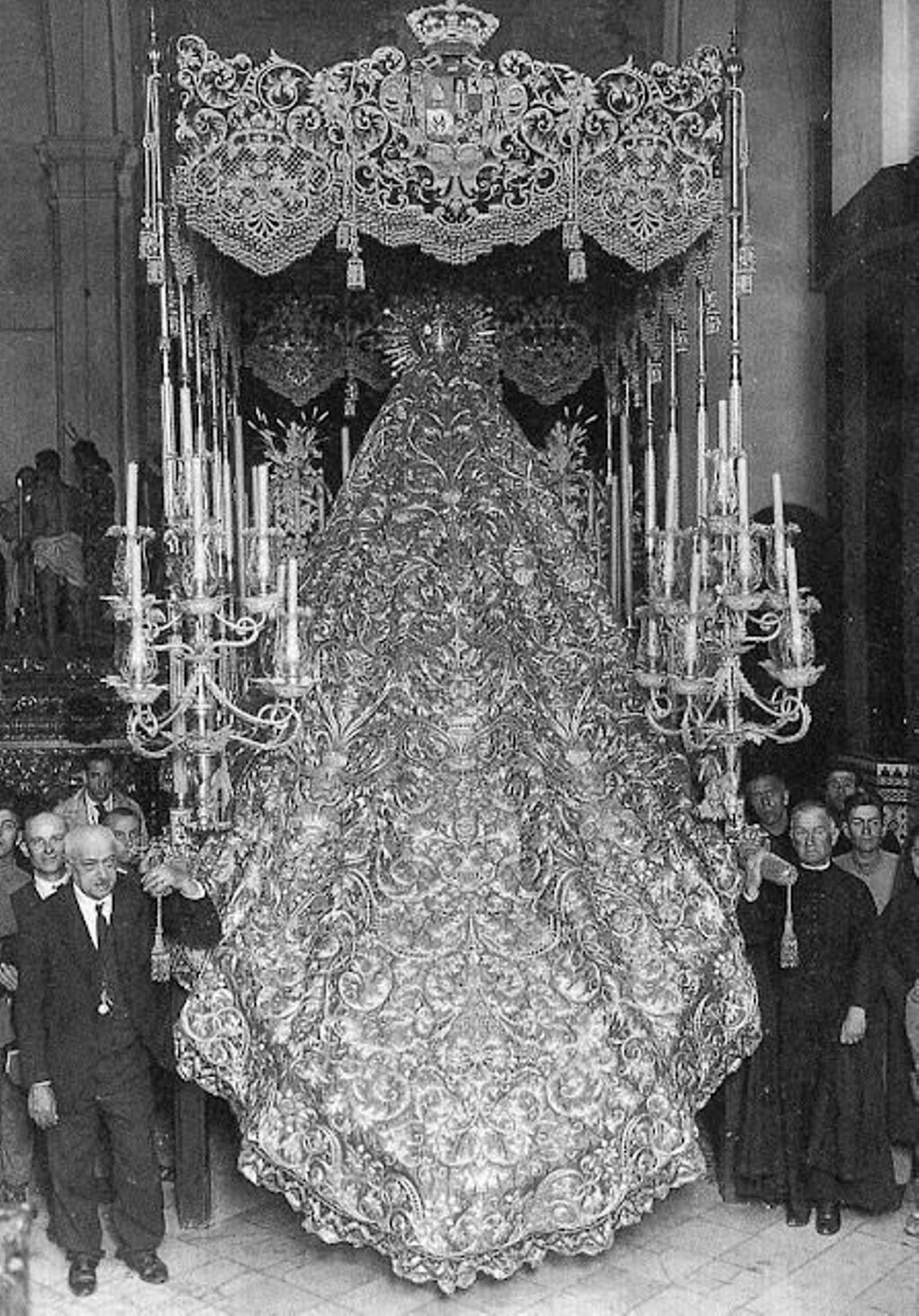 Rodríguez Ojeda, a la izquierda, junto al fundamental palio rojo de la Macarena y el manto de tisú.