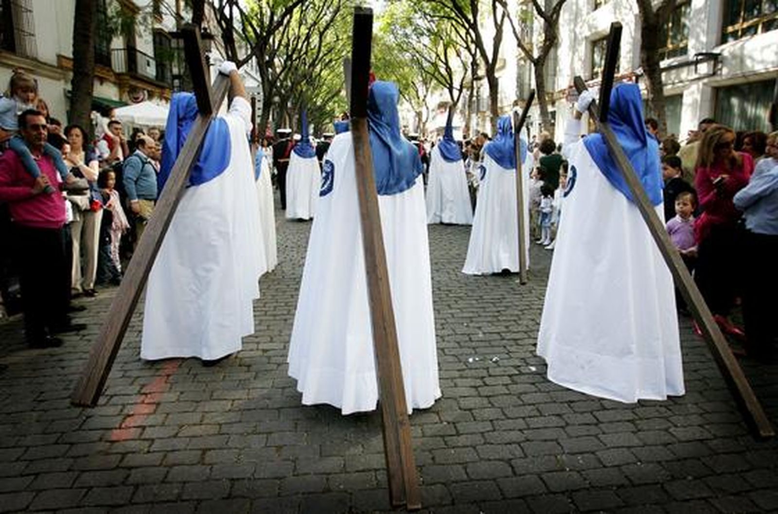 Nazarenos con cruces de penitencia por la calle Porvera.

Foto: Pascual