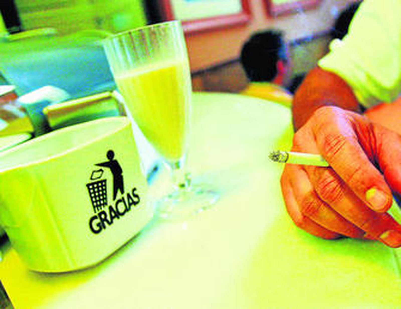 Un cliente fuma en una cafeteria antes de la entrada en vigor de la ley antitabaco.