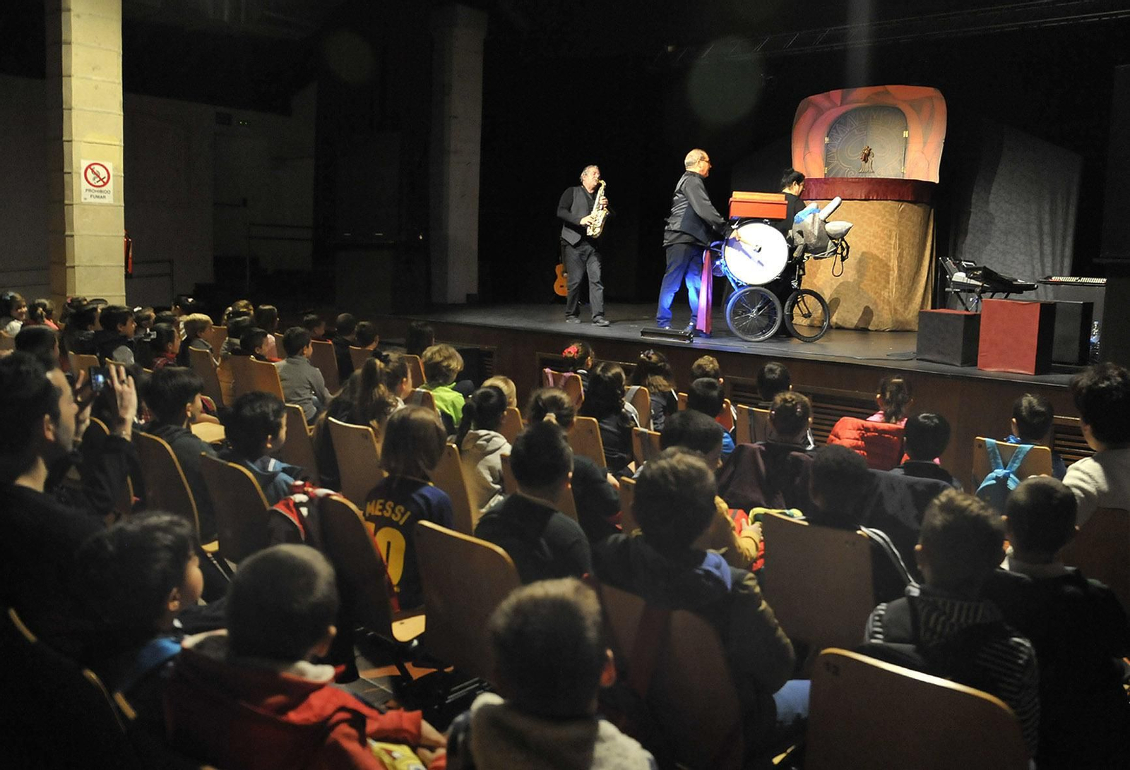 Alumnos accediendo a la Sala Paúl y, en la imagen inferior, presenciando los títeres.