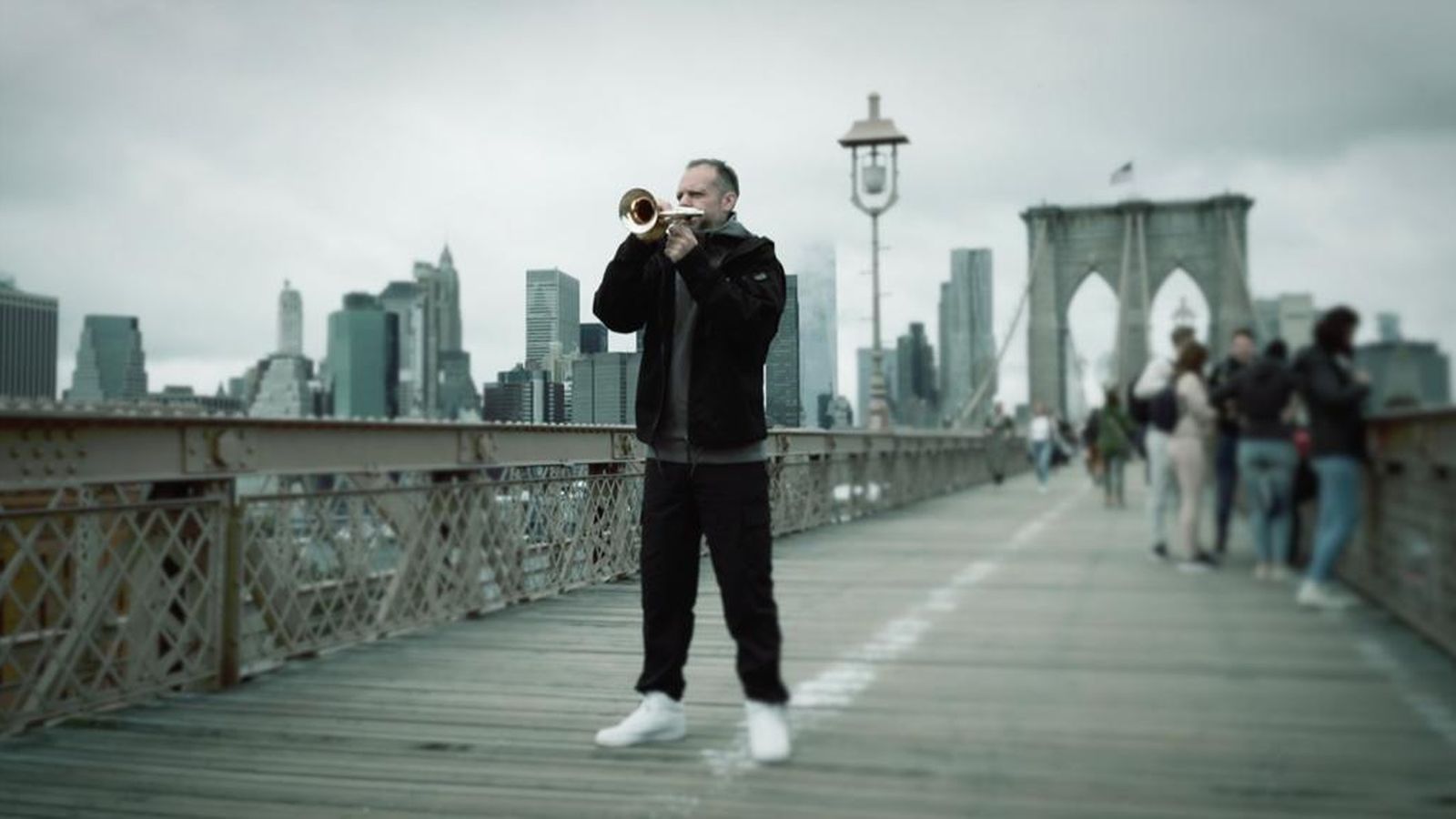 Dani de Baza toca la corneta en el puente de Brooklyn.