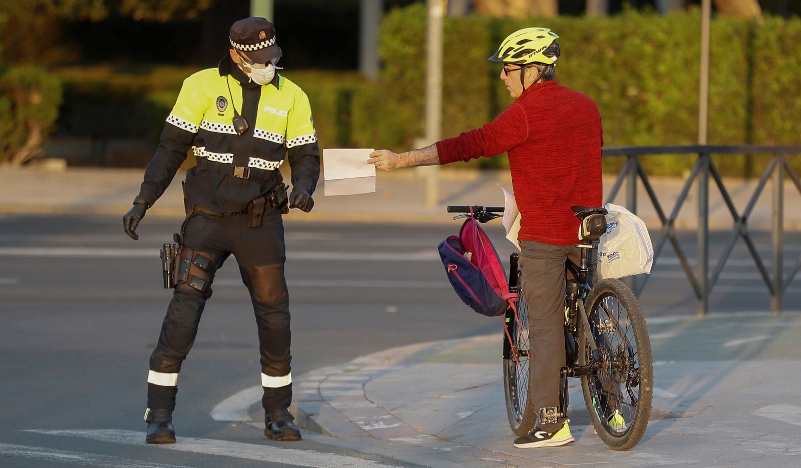 Un policía revisa la documentación de un ciclista durante el estado de alarma en Sevilla.