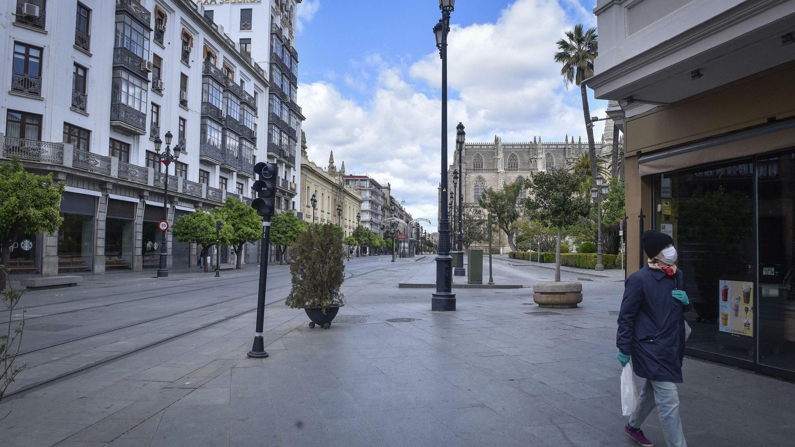 Una mujer con mascarilla pasea por el centro de la ciudad.