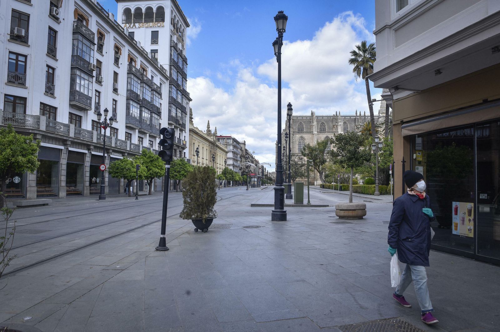 Una mujer con mascarilla pasea por el centro de la ciudad.