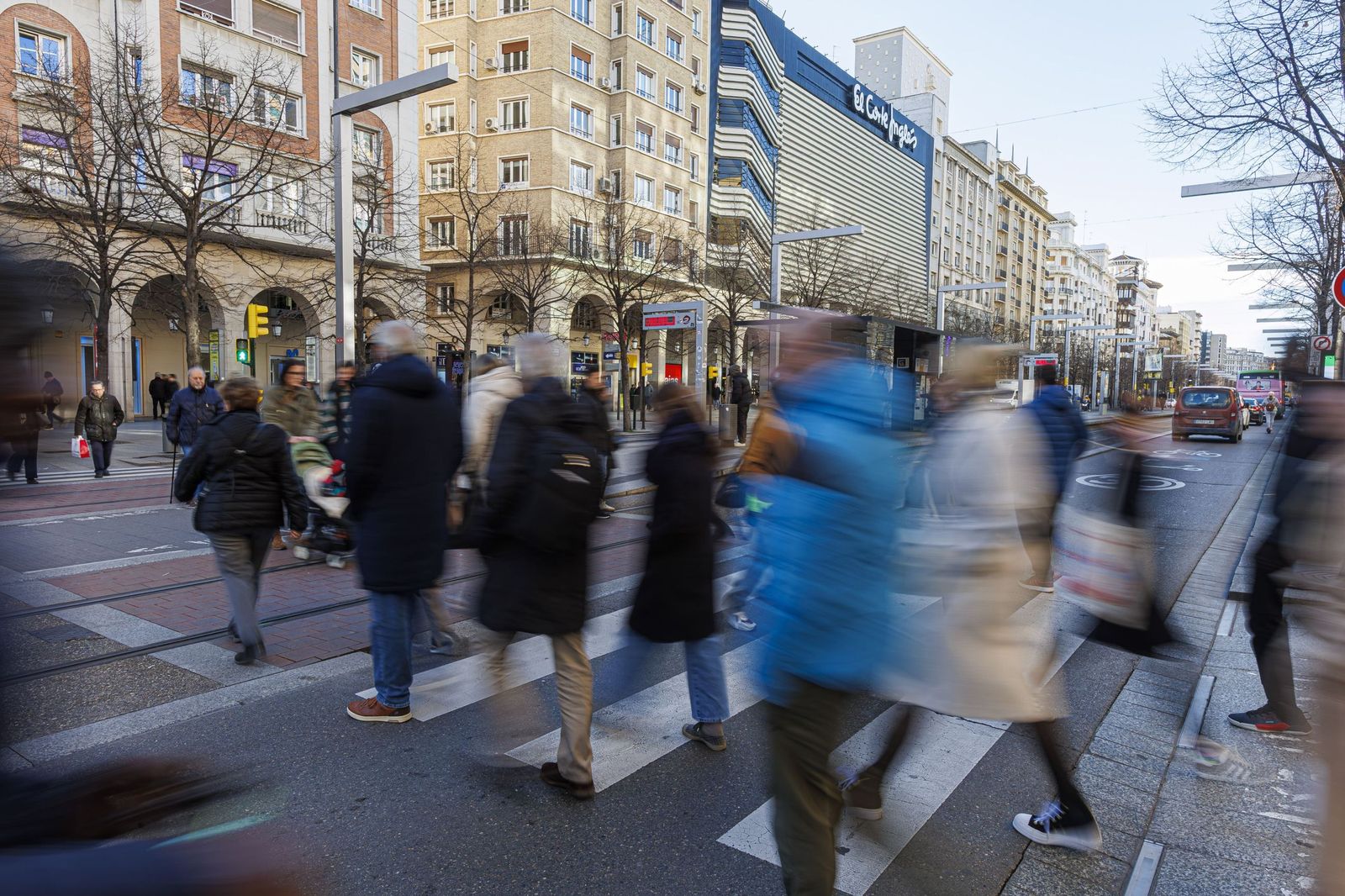 Numerosas personas cruzan un paso de peatones en Zaragoza.