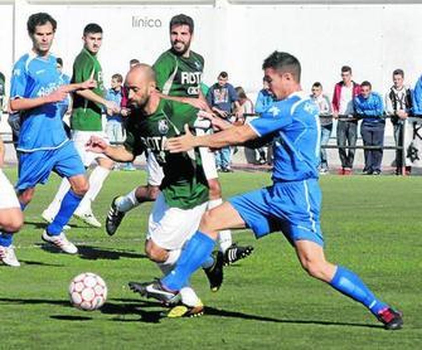 Dani intenta frenar a Migueli y Luis Castillo sigue la jugada desde atrás.