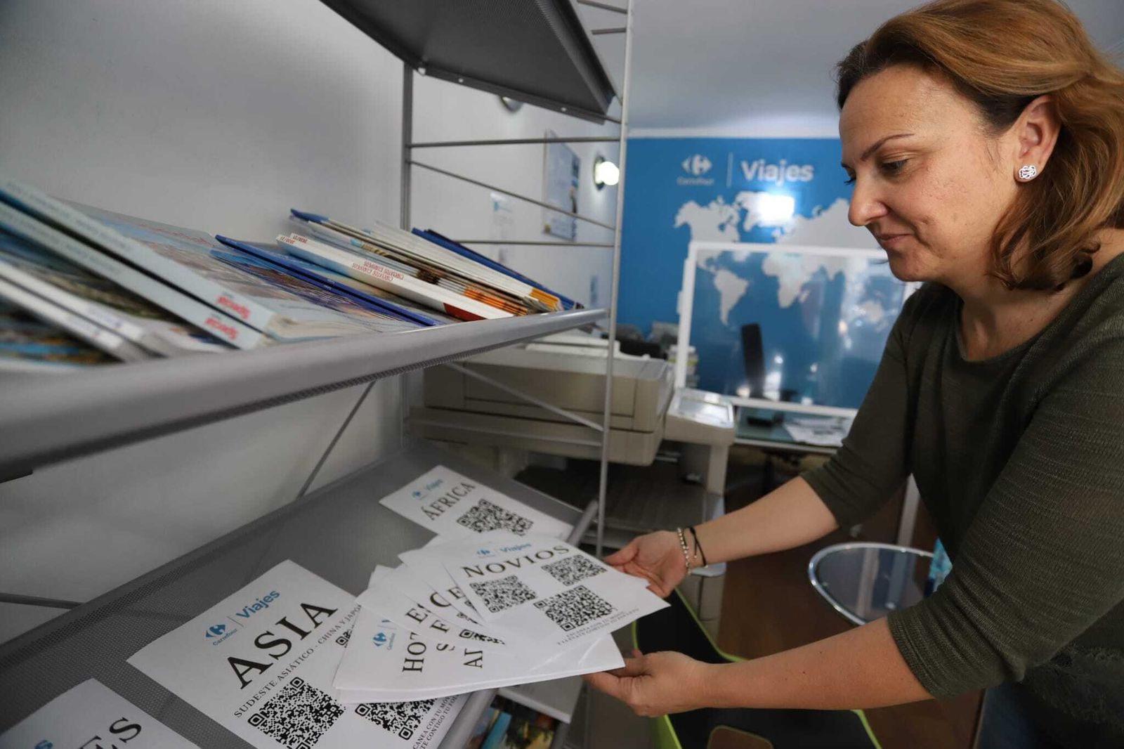 Colocación de folletos de viajes en una agencia.