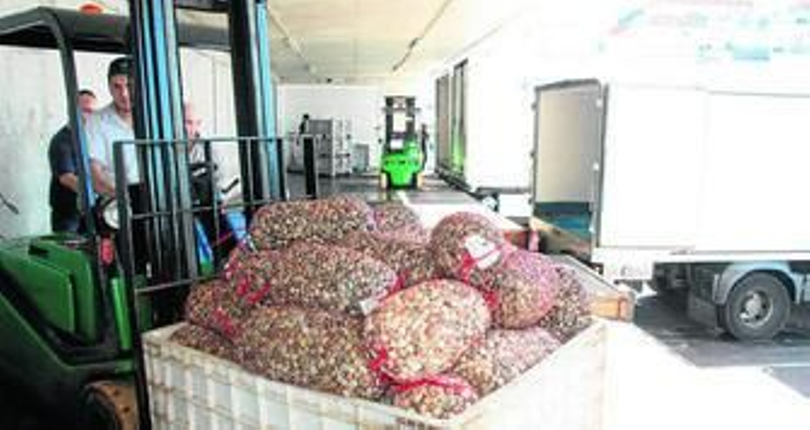 Un hombre, transportando chirlas en el muelle de Punta Umbría.