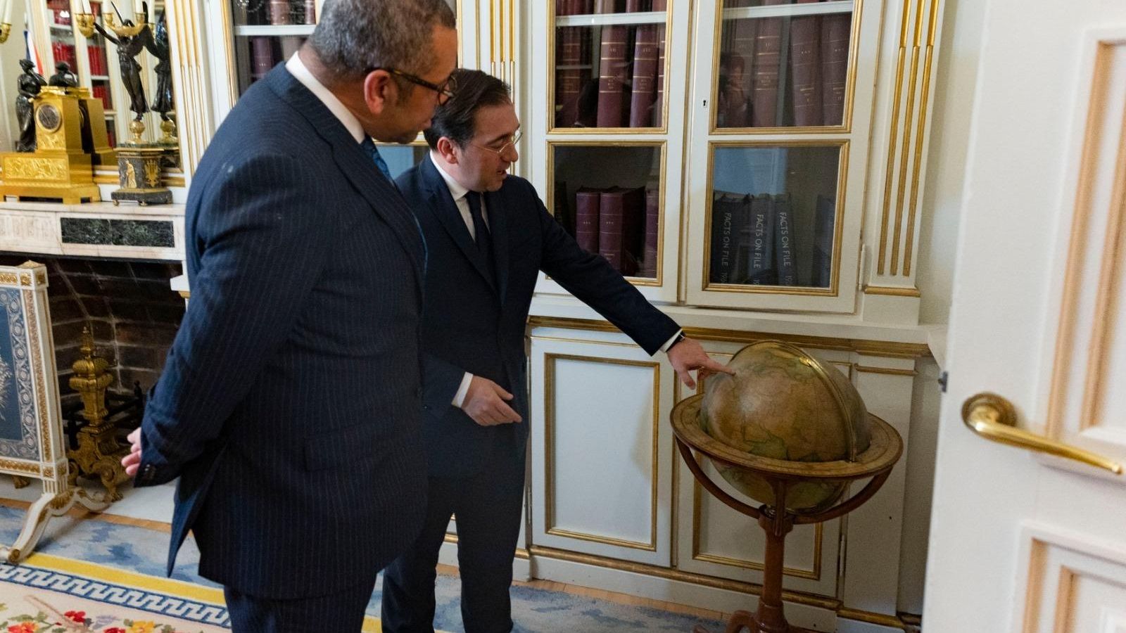 Albares señala un mapa del mundo en presencia de Cleverly.