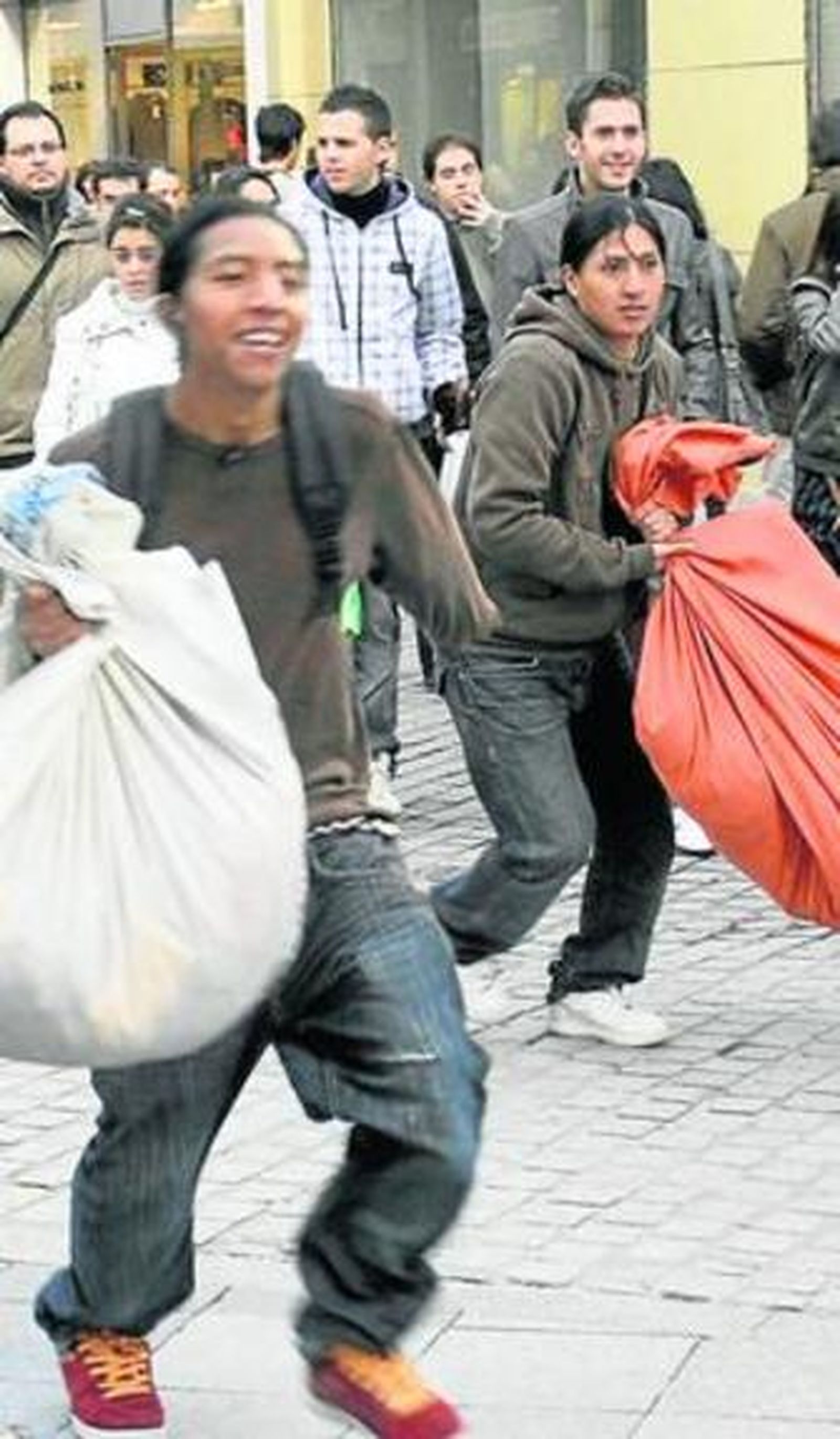 Dos vendedores de música y películas piratas huyen de la Policía.