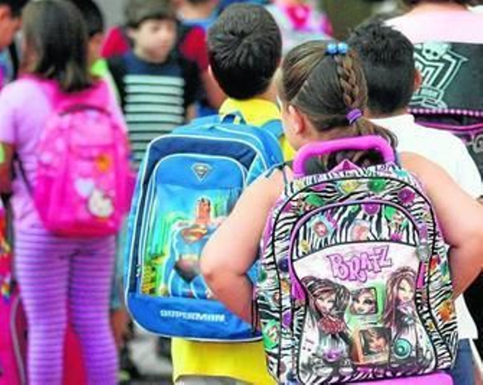 Varios pequeños cargan con sus mochilas el primer día de colegio.