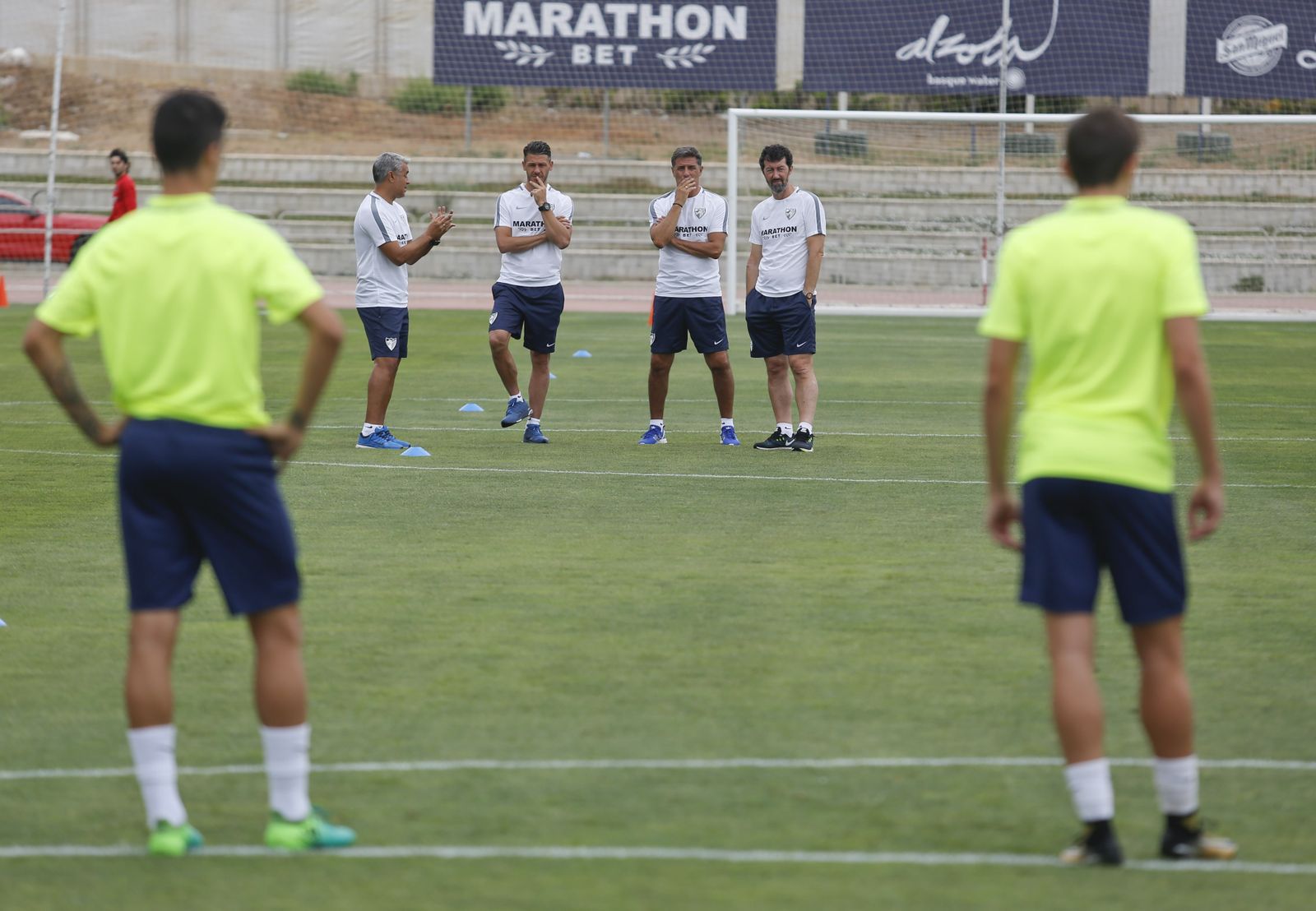 Los técnicos del Málaga contemplan un entrenamiento del equipo.