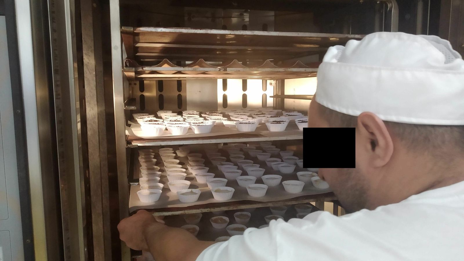 Uno de los internos introduce los muffins en el horno.