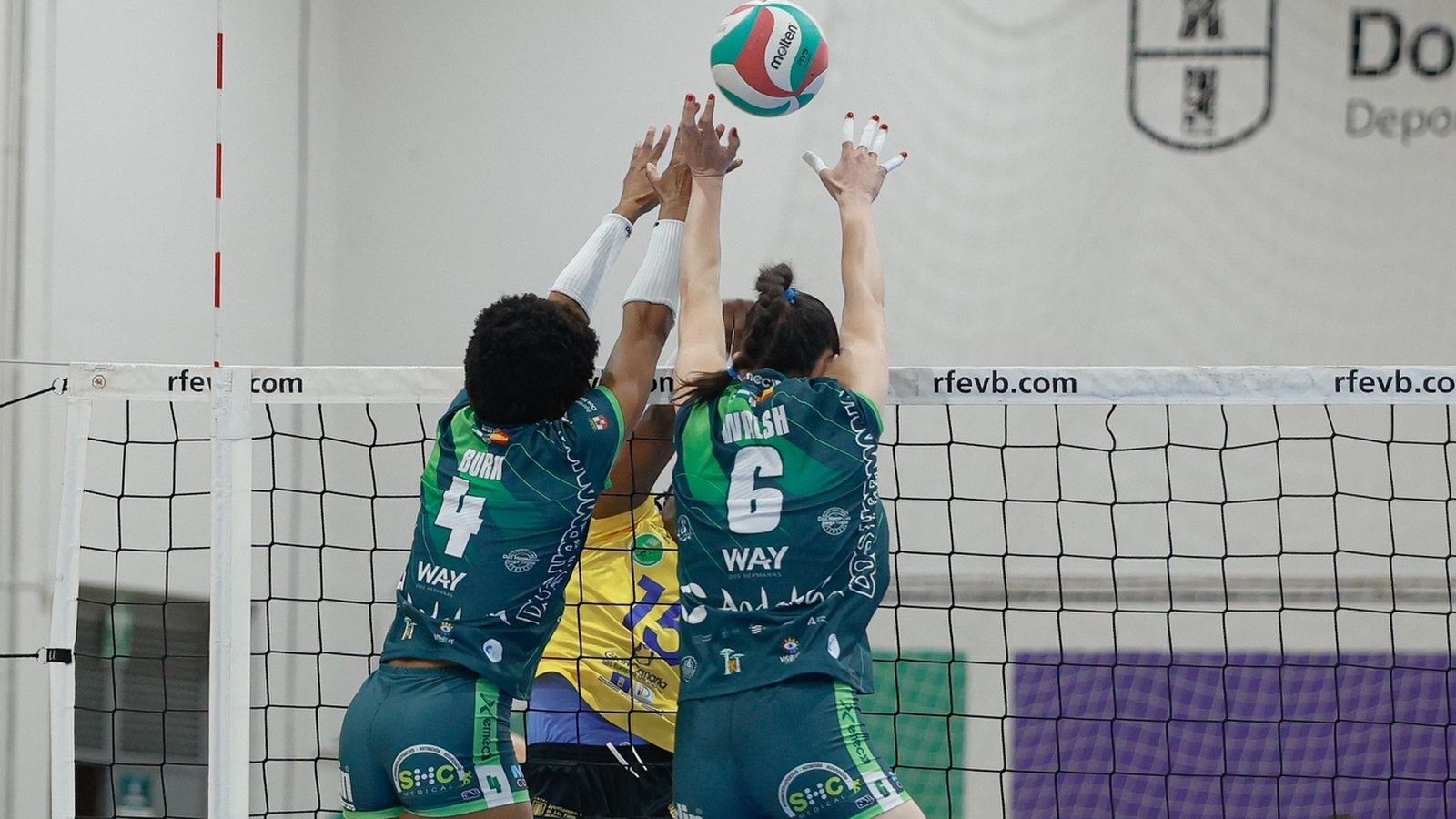 Las jugadoras del Esquimo Burk y Walsh tratan de bloquear el remate de Collar.