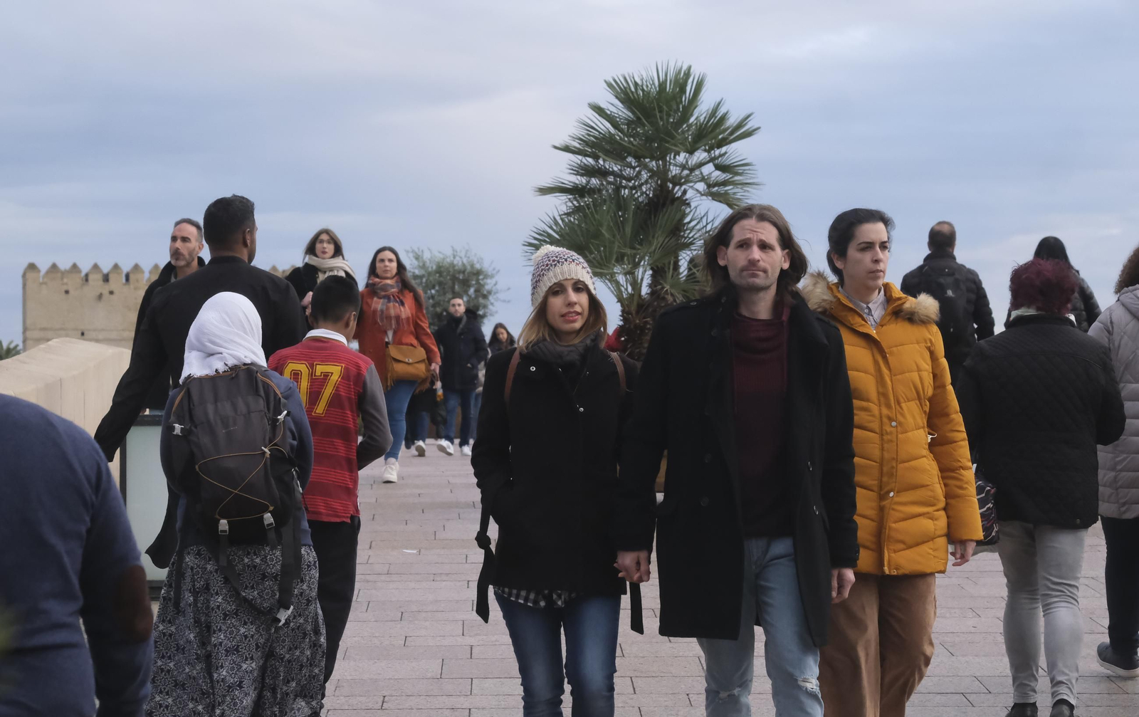 Personas caminan por el Puente Romano.