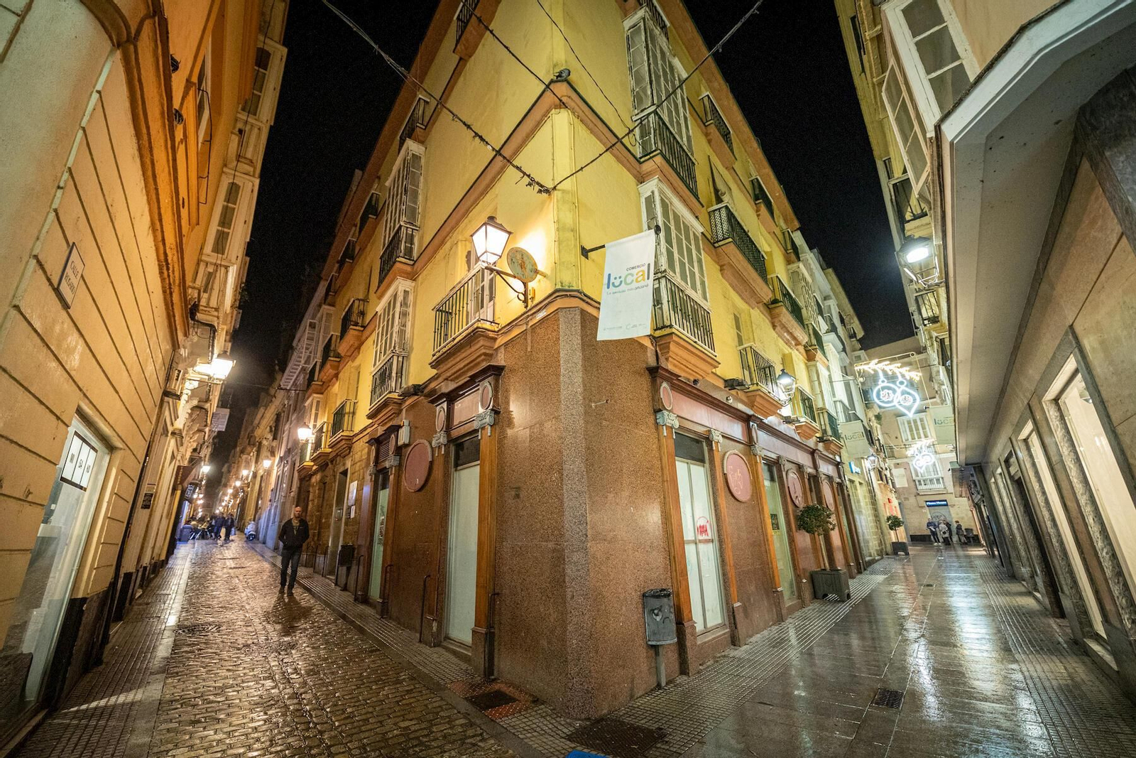 A la derecha, la calle Columela con iluminación navideña y a la izquierda, Rosario, sin ella.