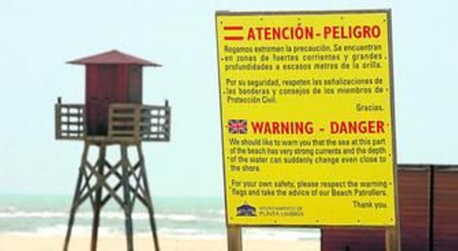 Cartel de advertencia y garita de socorro, en estos días aún cerrada, en la playa de La Bota.