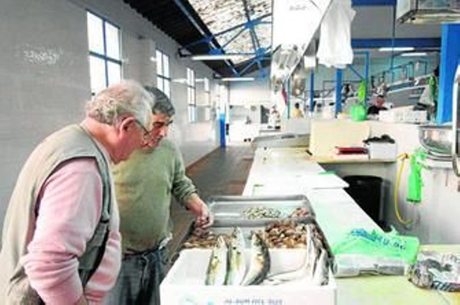 Dos hombres conversan sobre el pescado, ayer en el mercado La Concepción de La Línea.