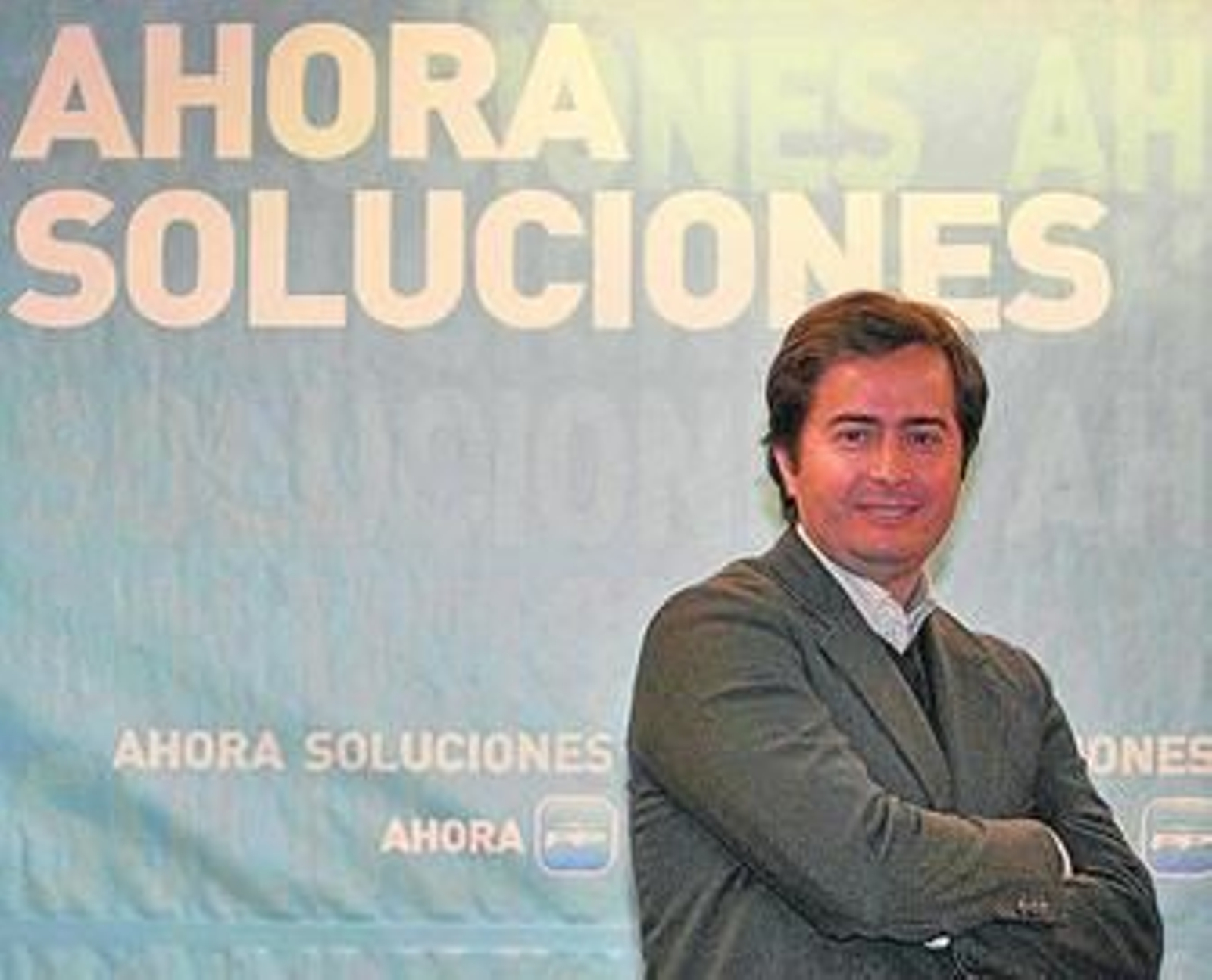 El candidato del PP en El Ejido posa ante el cartel de la sala de prensa de la sede provincial.