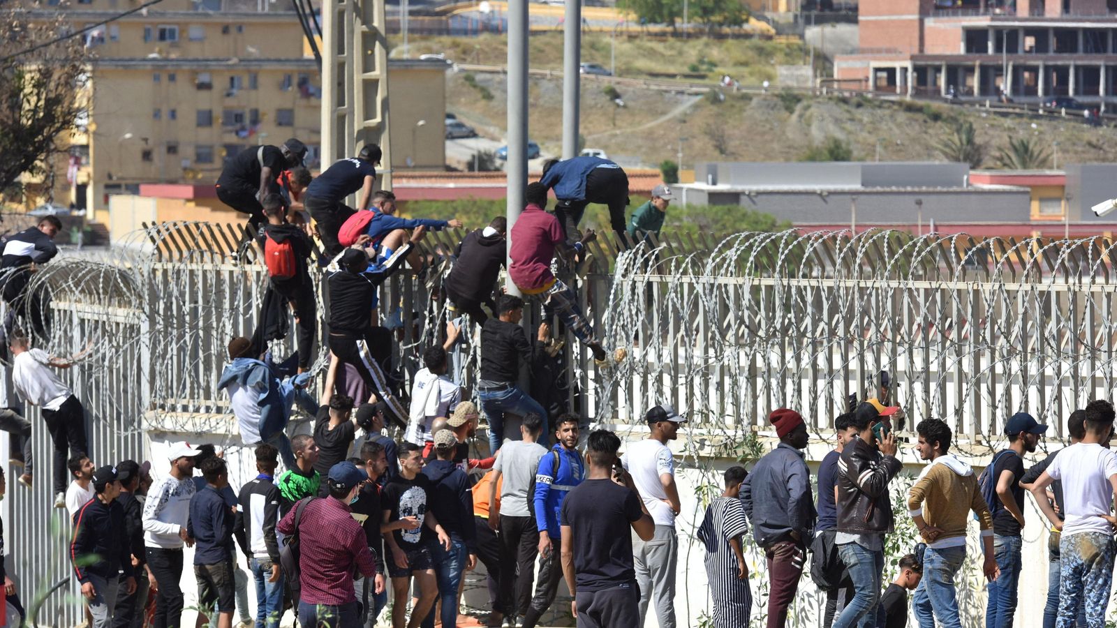 Decenas de inmigrantes saltan la valla que separa la ciudad de Ceuta de Marruecos.