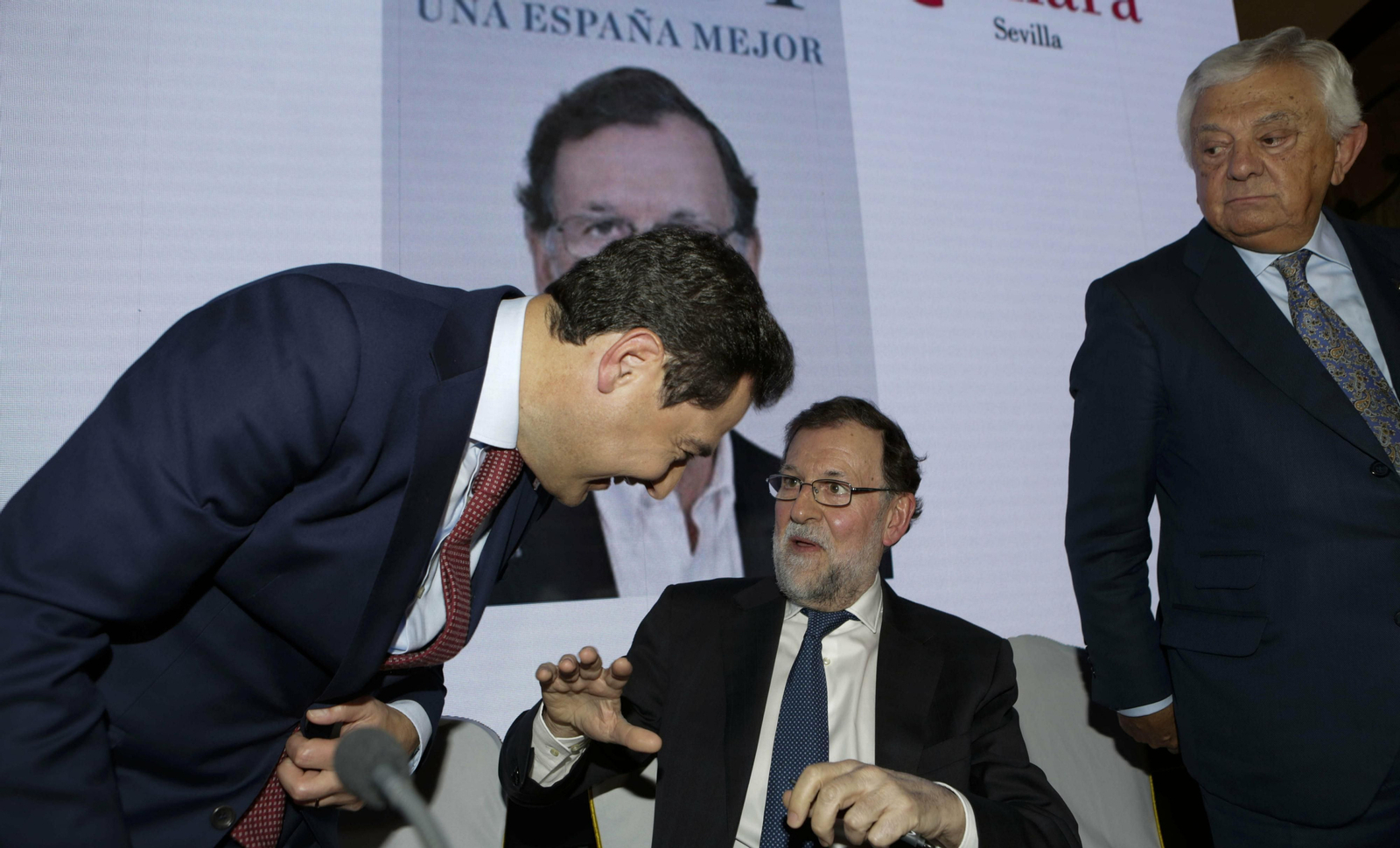 Juanma Moreno bromea con Mariano Rajoy, en el hotel Alfonso XIII.