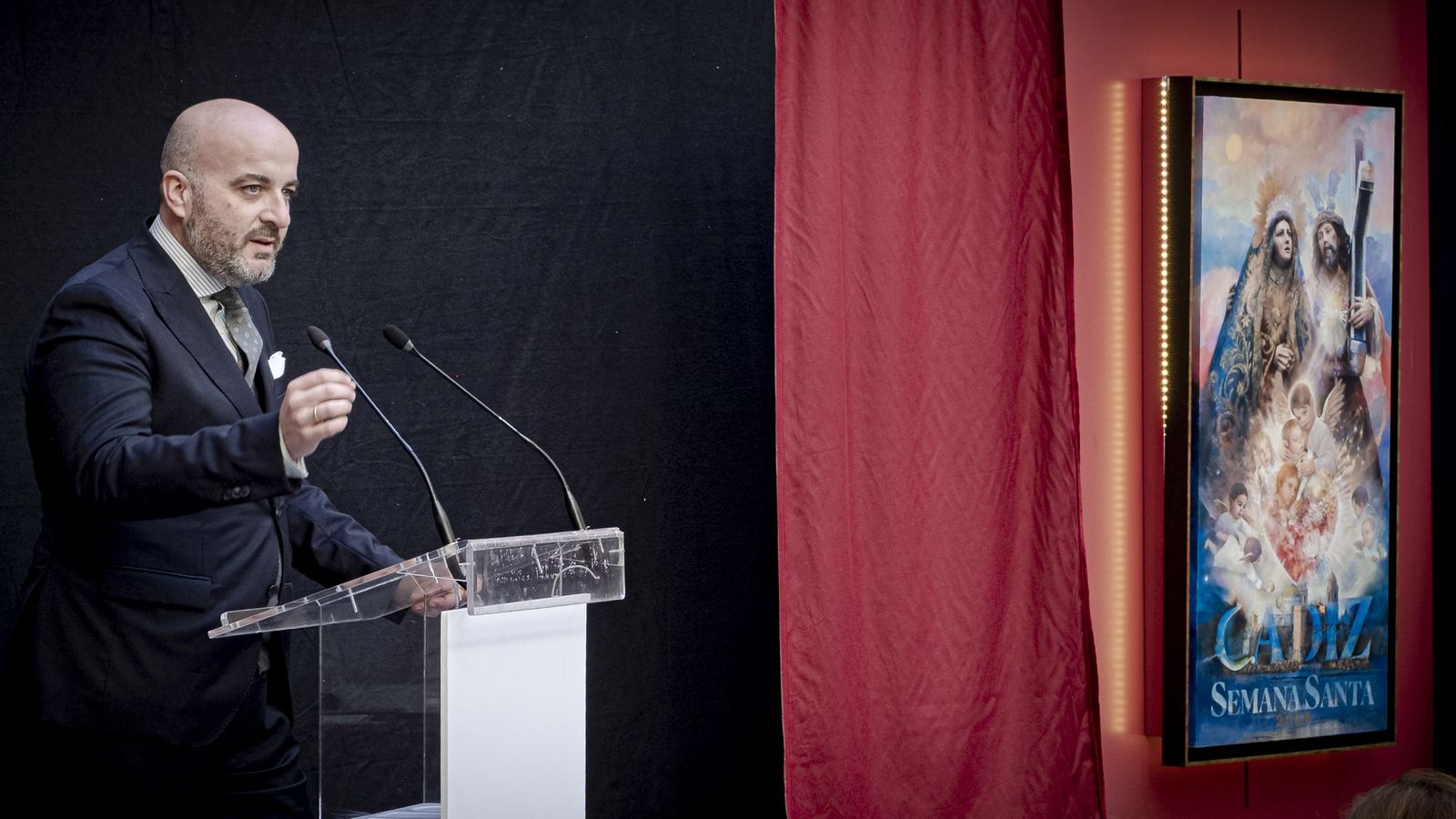 El pregonero, pablo Durio, junto al  cartel de la Semana Santa de Cádiz 2026