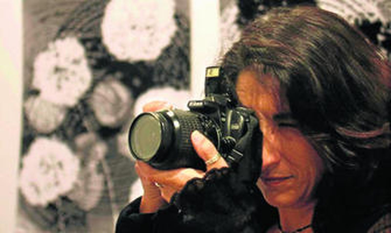 Una fotógrafa toma una imagen durante la inauguración de la exposición de Ilan Wolf.