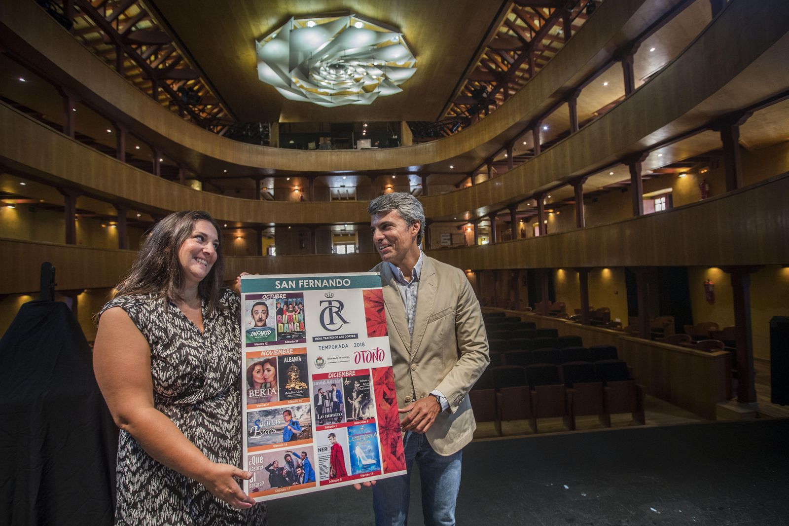 Castro (i.) y Romero, con el cartel de los espectáculos de la temporada de Otoño del Teatro de Las Cortes, en el escenario del coliseo isleño.