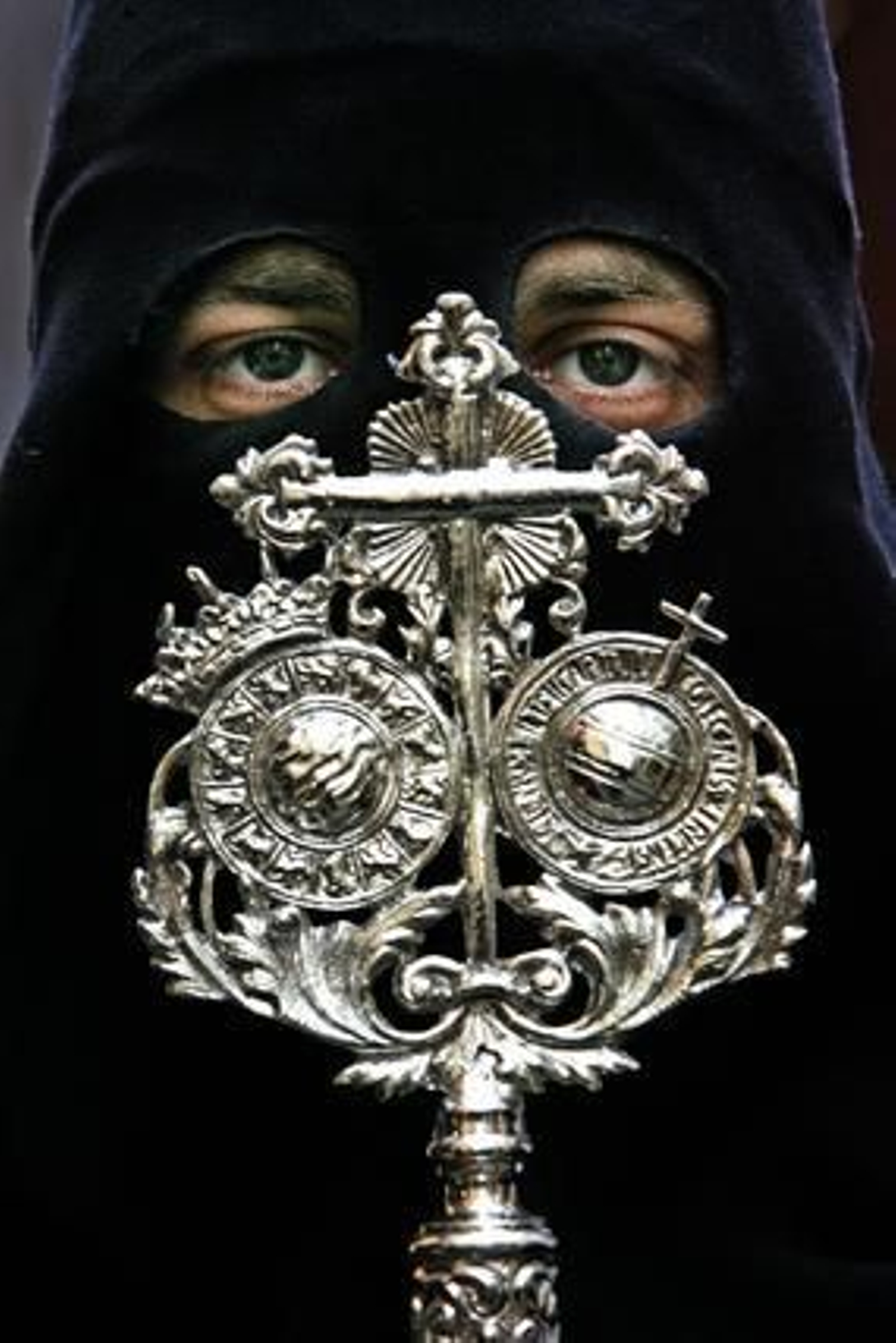 Mirada. Un hermano del cortejo del Santísimo Cristo de la Viga mira a la cámara mientras sostiene ante sí el escudo de esta catedralicia hermandad que remata la vara que porta.

Foto: Vanesa Lobo