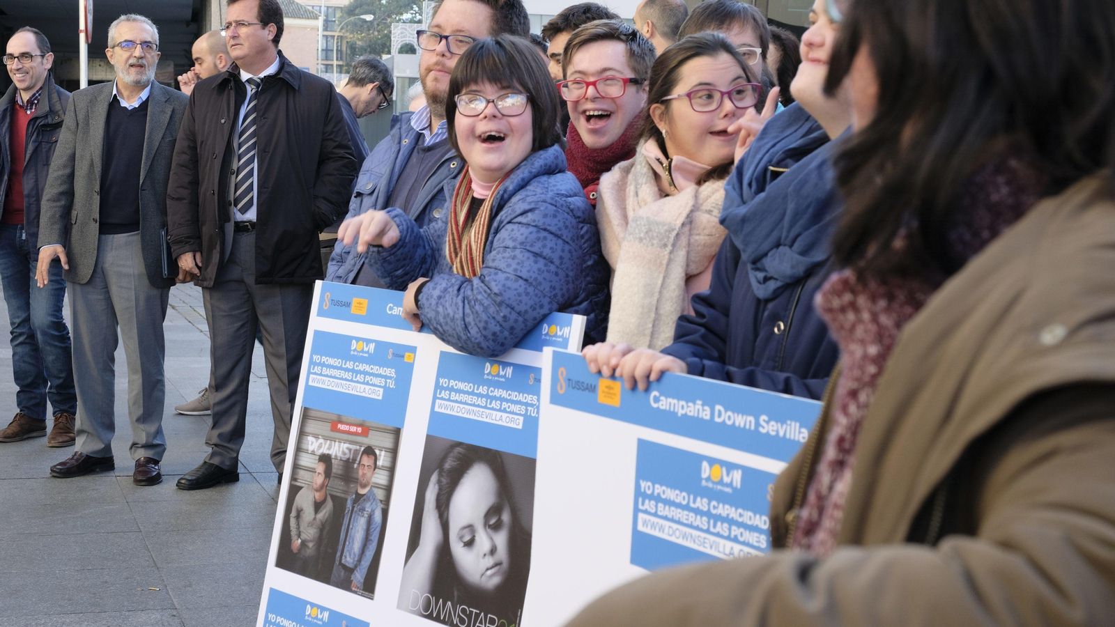 Miembros de Down Sevilla, protagonistas de la campaña 'Yo pongo las capacidades, las barreras las pones tú', posan junto a sus fotografías.