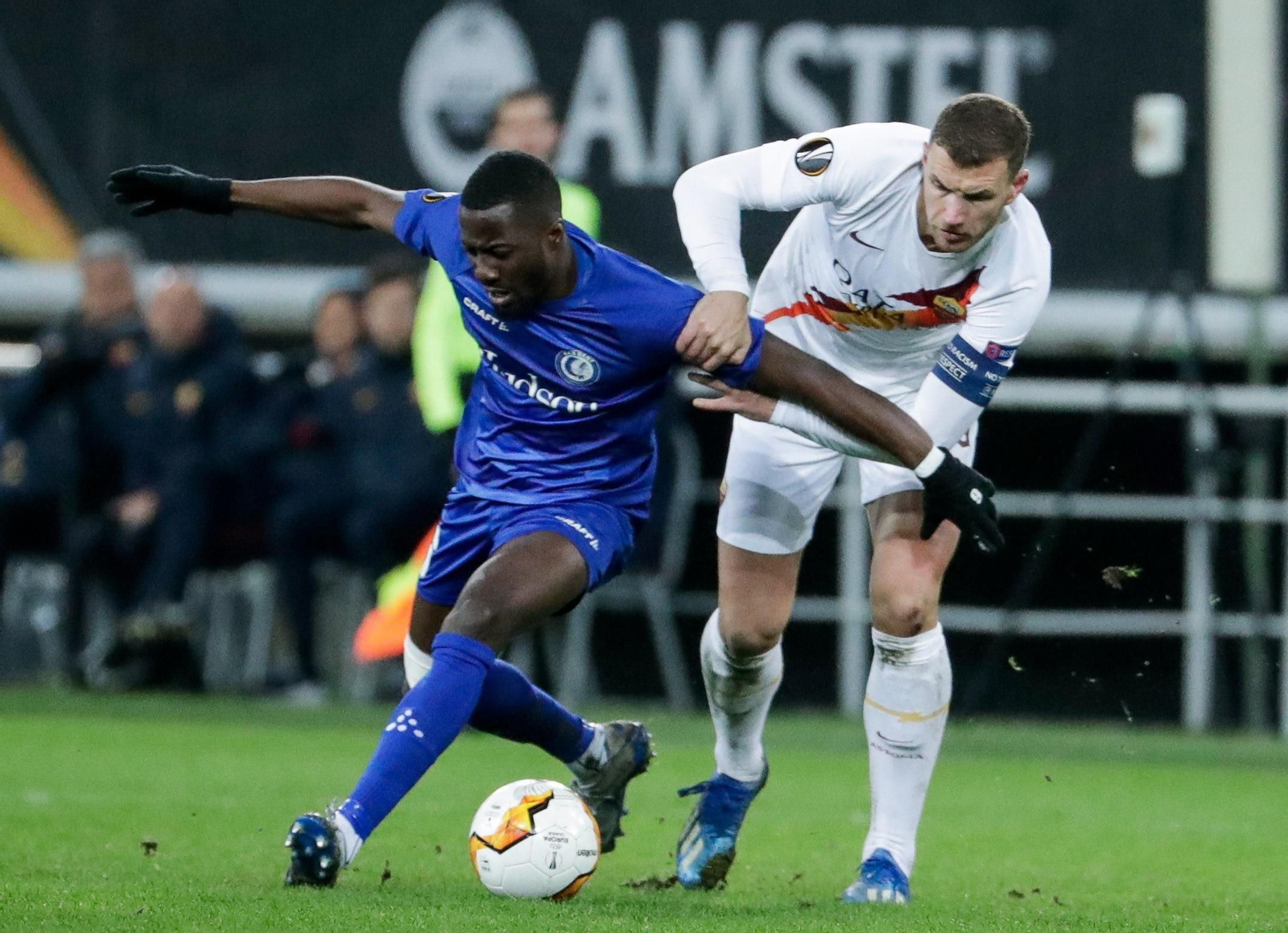 Owusu aguanta el balón ante Dzeko en el Gent-Roma de Europa League, en febrero.