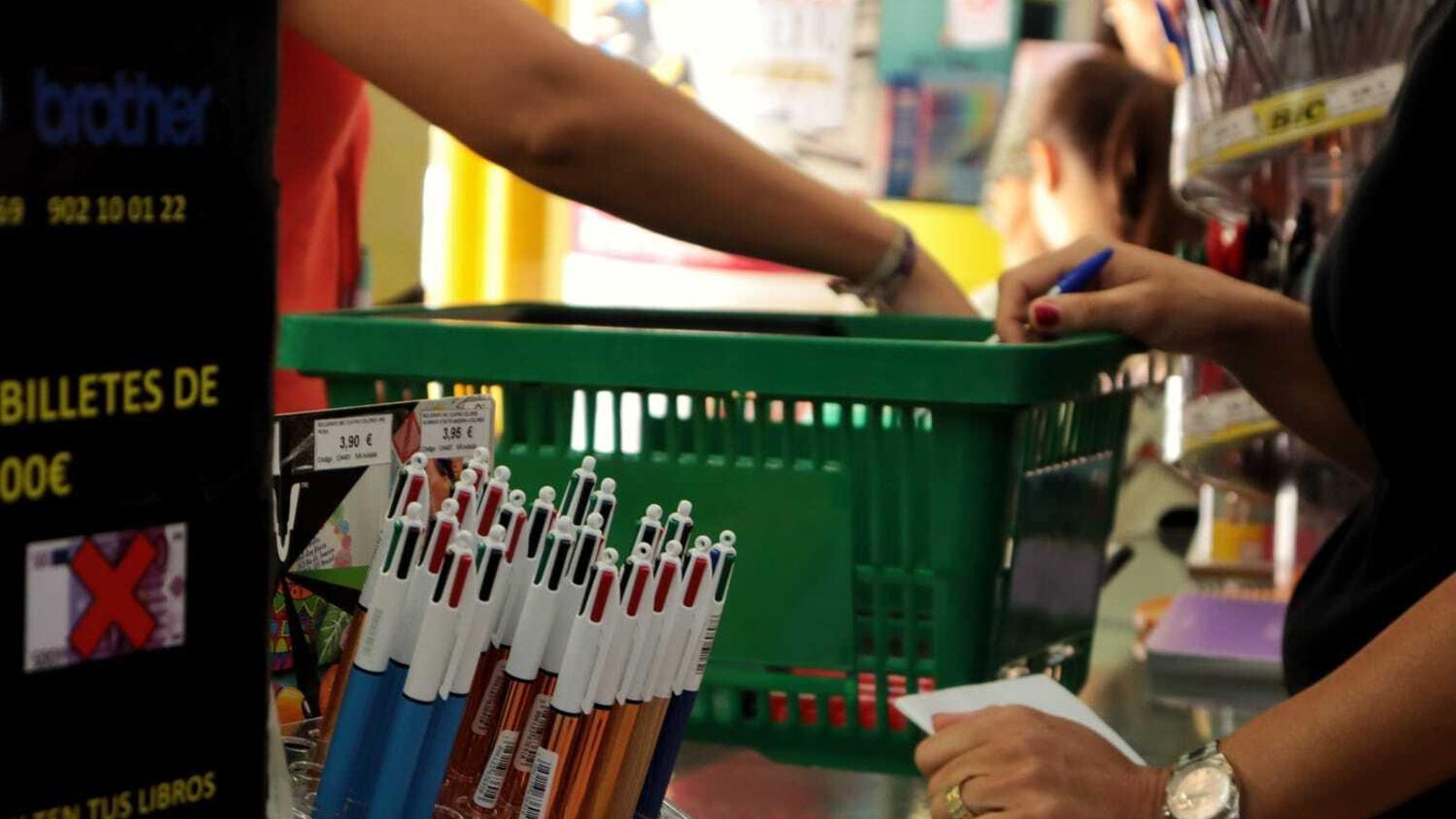 Una mujer comprando material escolar en una papelería. Una mujer comprando material escolar en una papelería.