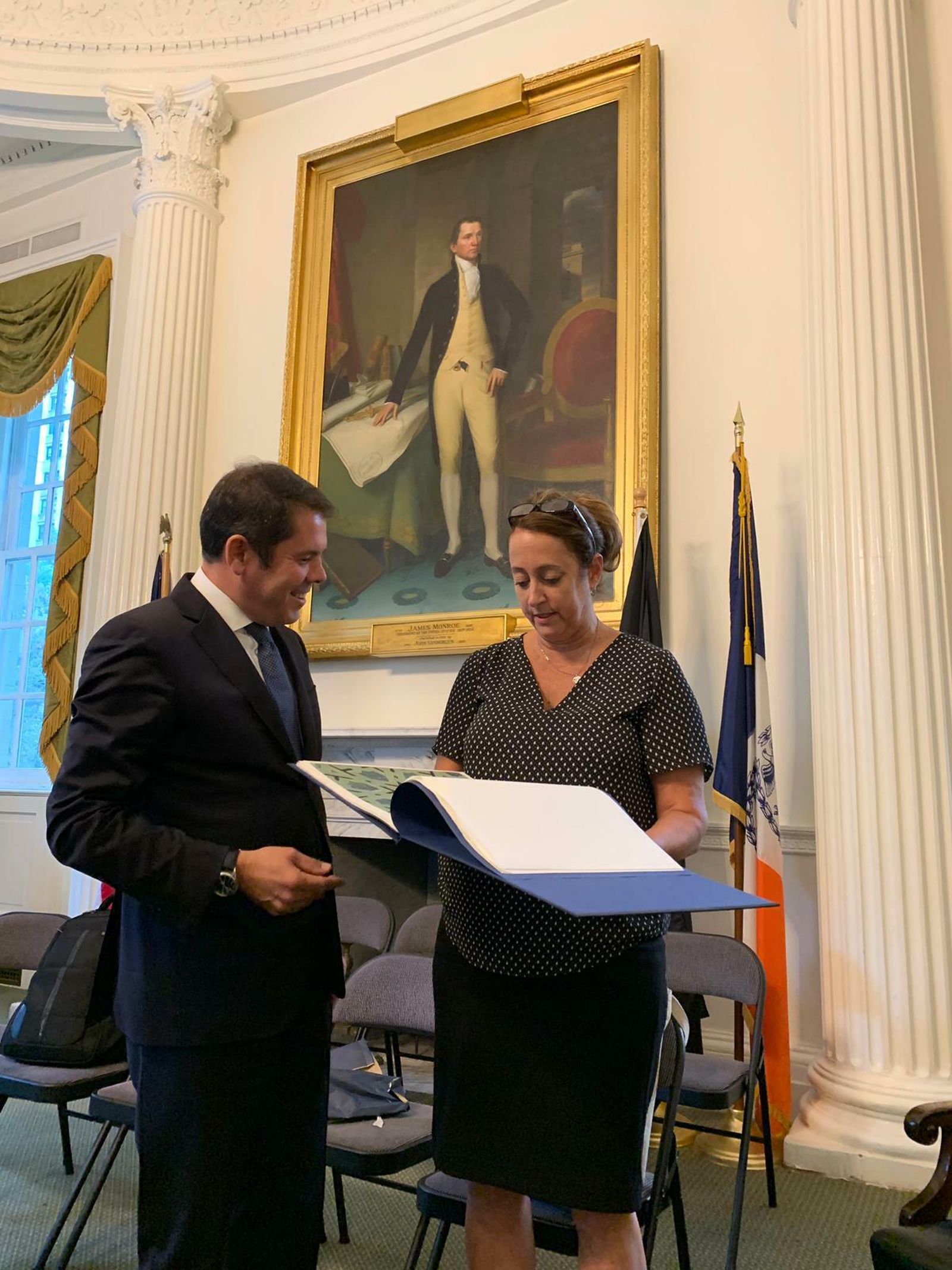 Cuerva entrega un libro sobre La Alhambra como obsequio a Laura Anglin.