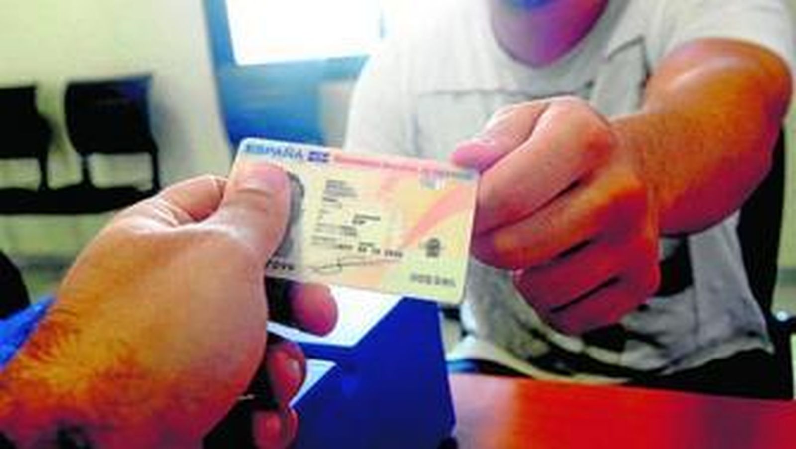 Un funcionario entrega el nuevo DNI a un ciudadano.