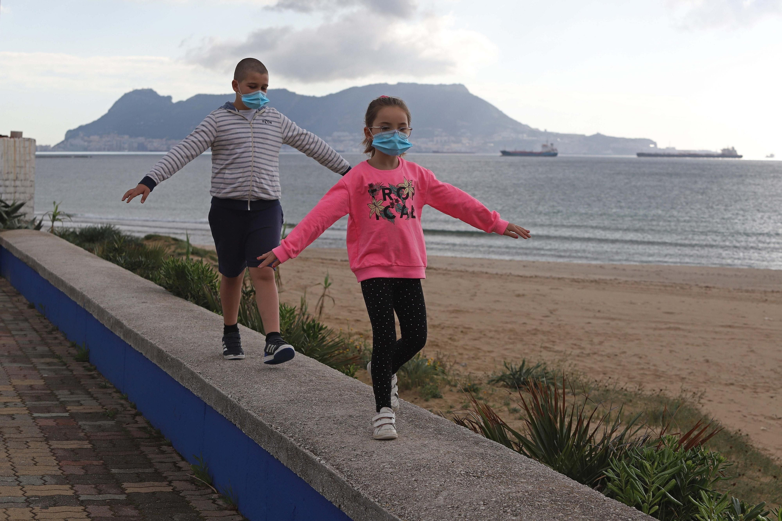 Un niño y una niña juegan por el paseo marítimo de Getares, en Algeciras.